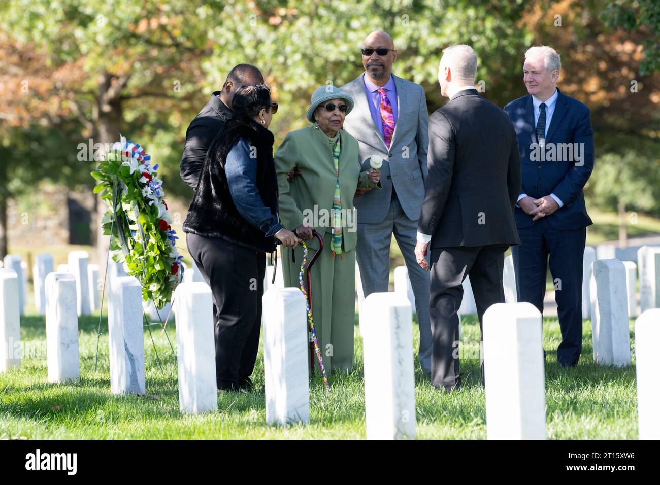 Joann Woodson keeps a flower after placing a wreath at the headstone of