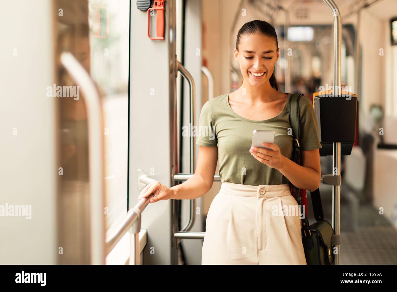 Smiling woman passenger using mobile phone on a tram indoor Stock Photo