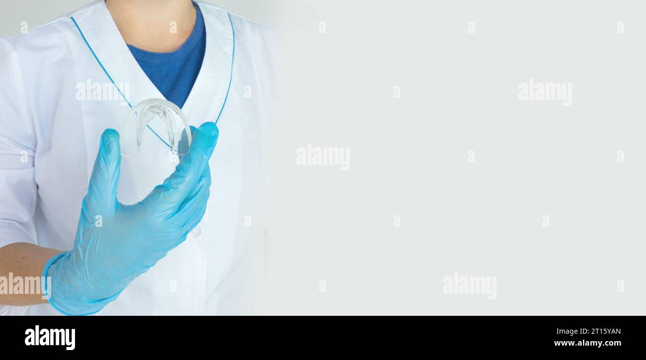 Tooth whitening, a tooth mold in doctors hand. Dental beauty treatment. Teeth retaining tools