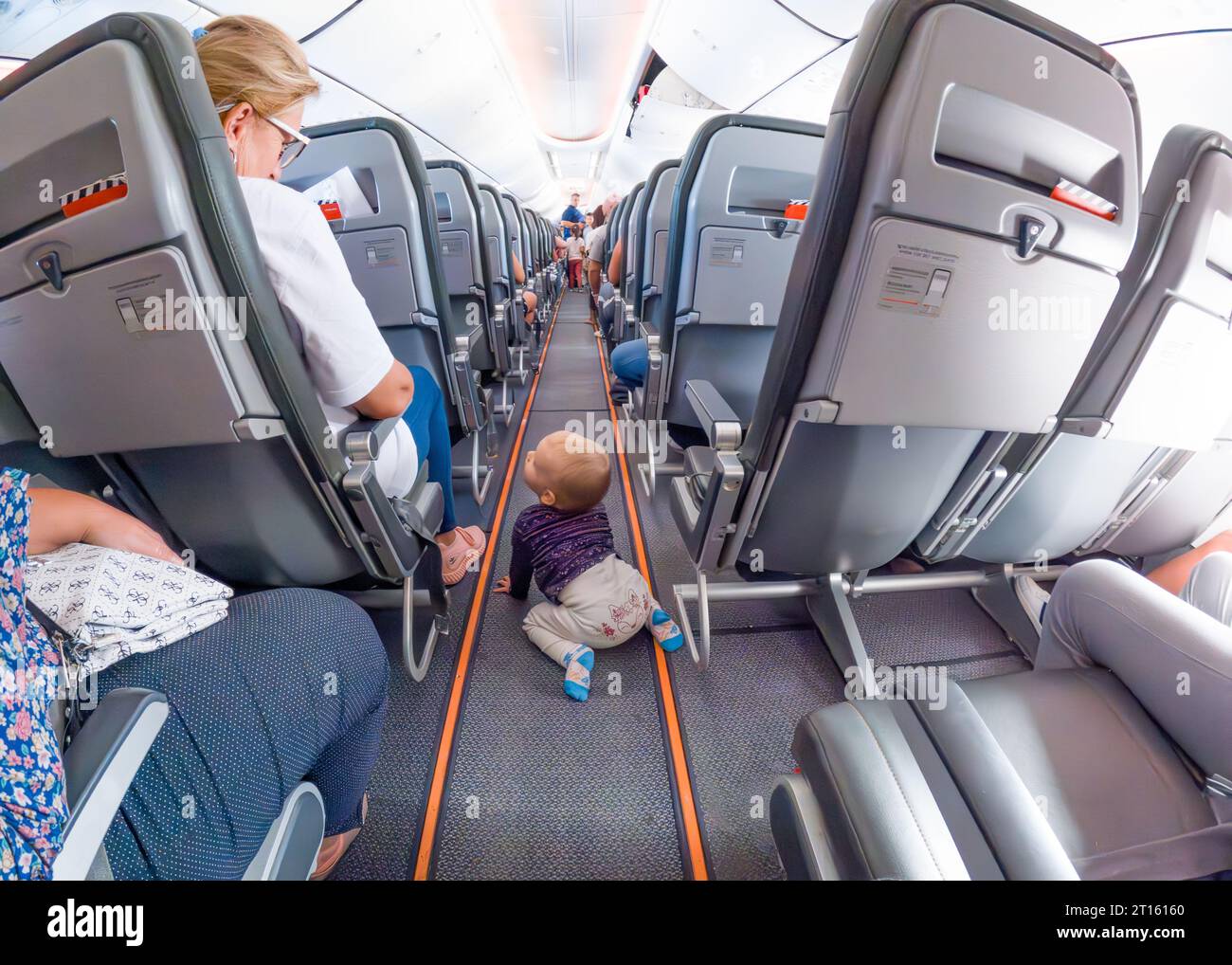 1 year old baby walks on his knees between seats on plane during flight
