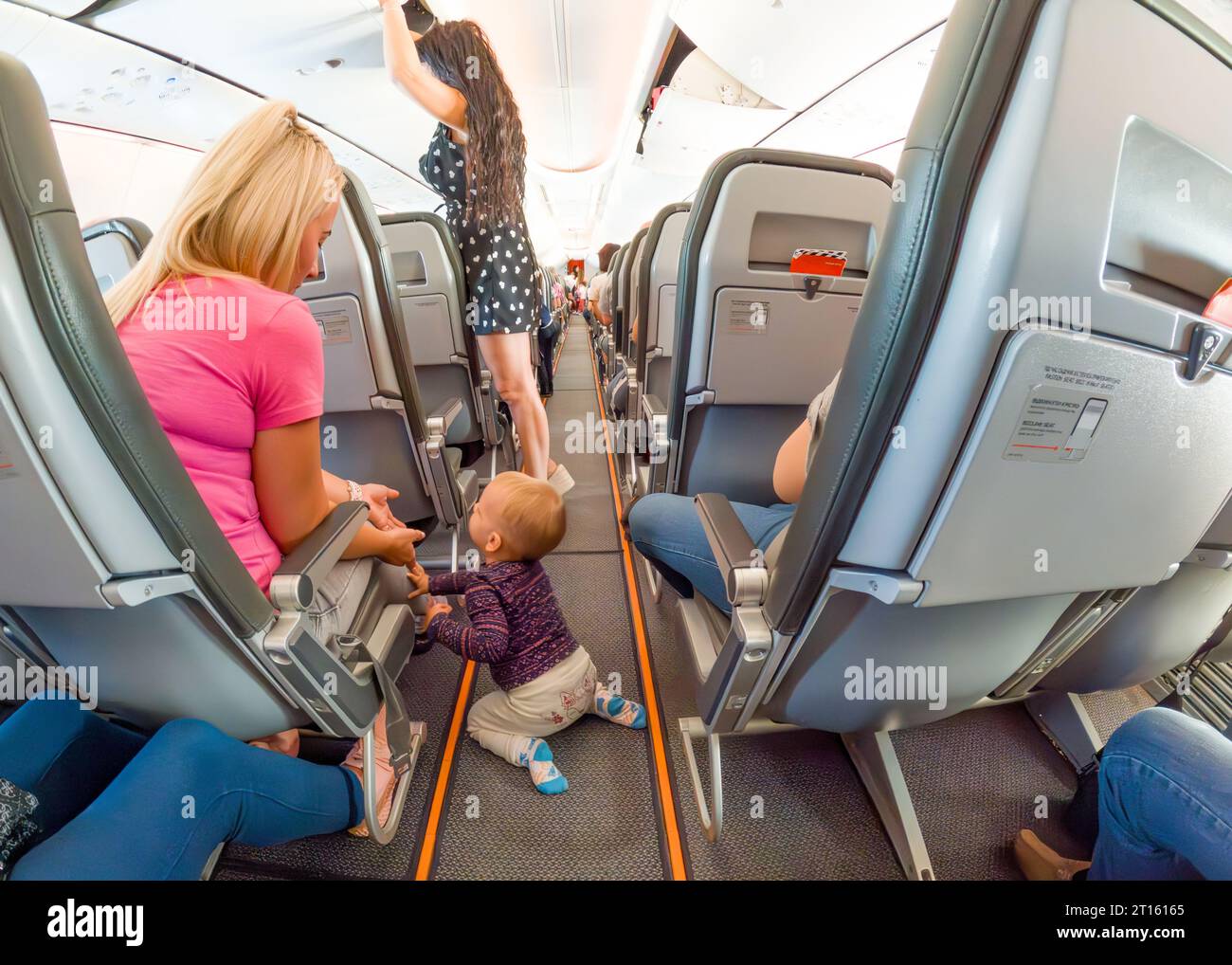 1 year old baby walks on his knees between seats on plane during flight