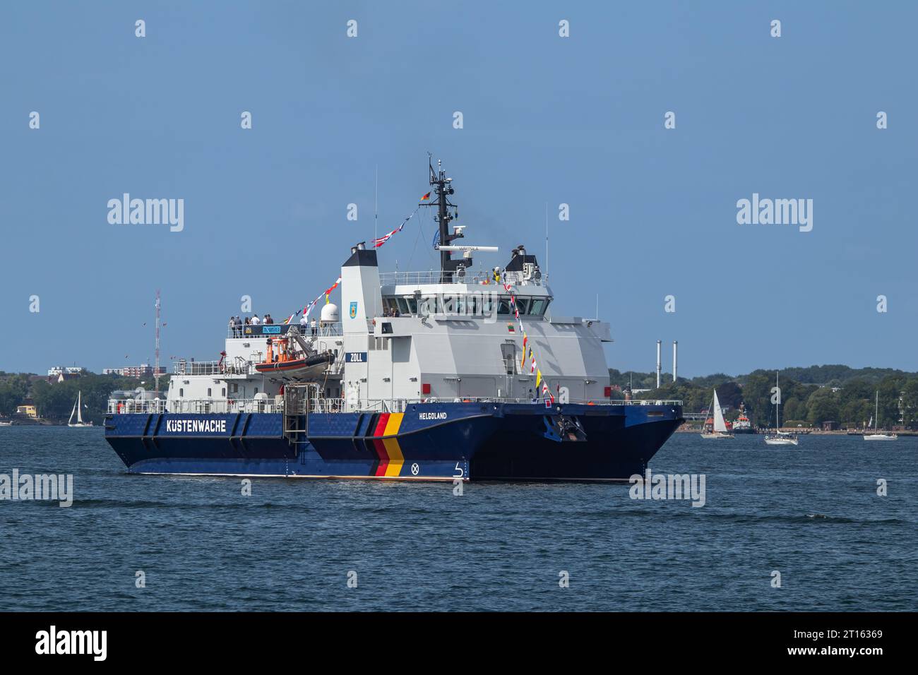 Kiel, Schleswig-Holstein, Germany. 24th June, 2023. The SWATH (small waterplane area twin hull) Helgoland (built in 2009), a patrol vessel of the Federal Customs Service of Germany and of the German Federal Coast Guard, takes part in the Tall Ships Parade (Windjammerparade) in Kieler Förde bay of Baltic Sea with about 60 tall ships, traditional sailing ships, steamboats and hundreds of sailing yachts as part of the Kiel Week 2023 (Kieler Woche), an annual sailing event in Kiel. Stock Photo
