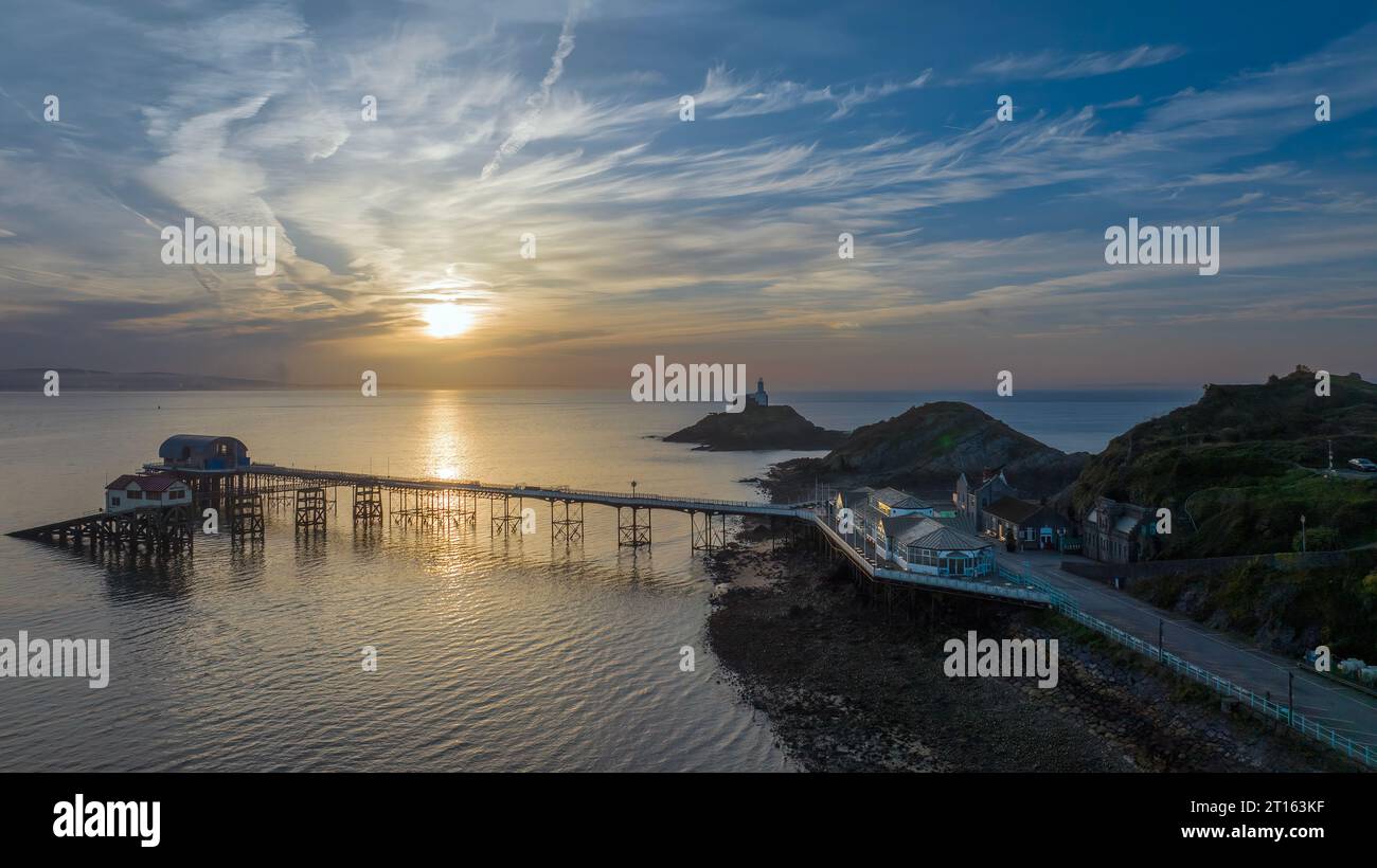 Editorial Swansea, UK - October 08, 2023: Sunrise over Mumbles lighthouse, pier and Beach Hut Cafe in Swansea, UK Stock Photo