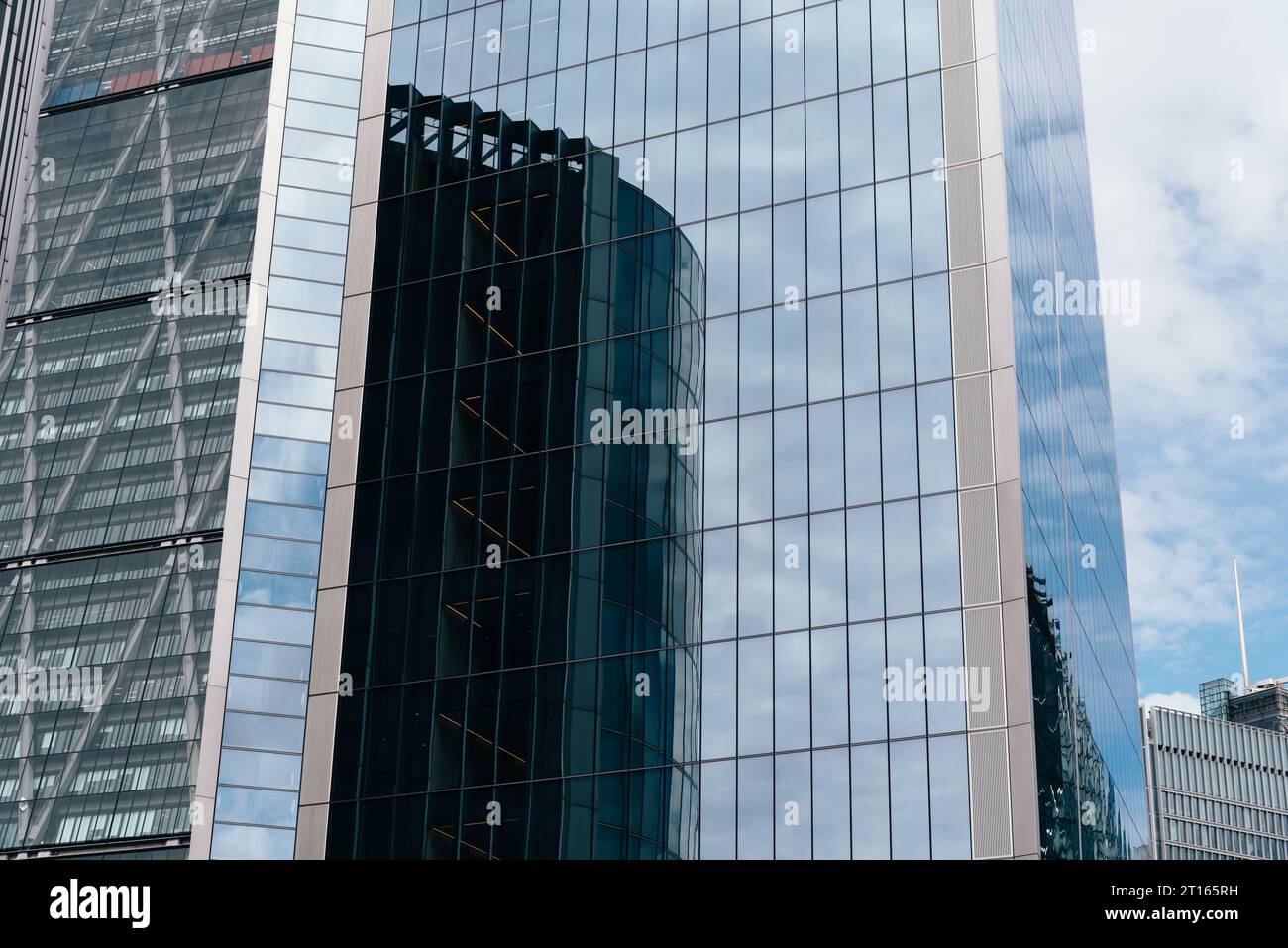 London, UK - August 25, 2023: Reflections on curtain wall glass facade of modern office skyscrapers in the City of London. Stock Photo
