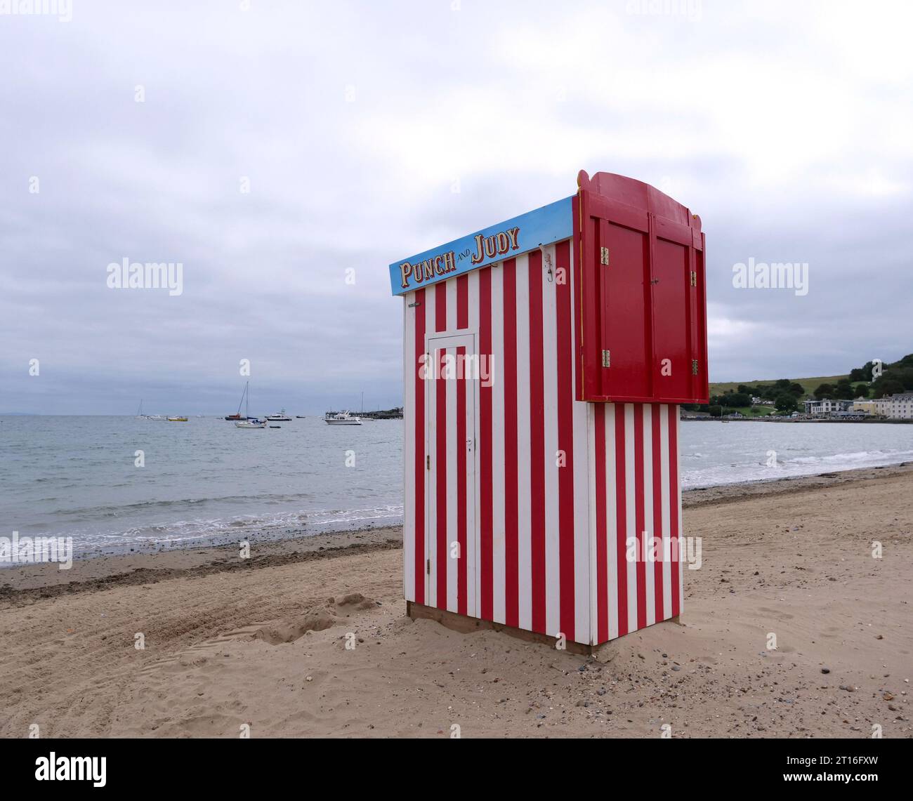Photograph of a Punch and Judy Show. wooden stall on the beach at Swanage England This is a children's puppet show on  a beach. Stock Photo