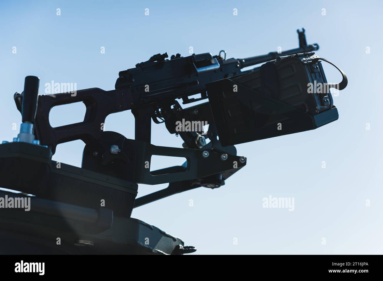 Closeup shot of medium machine gun against the background of sunny blue sky. Belt-fed machine gun. High quality photo Stock Photo