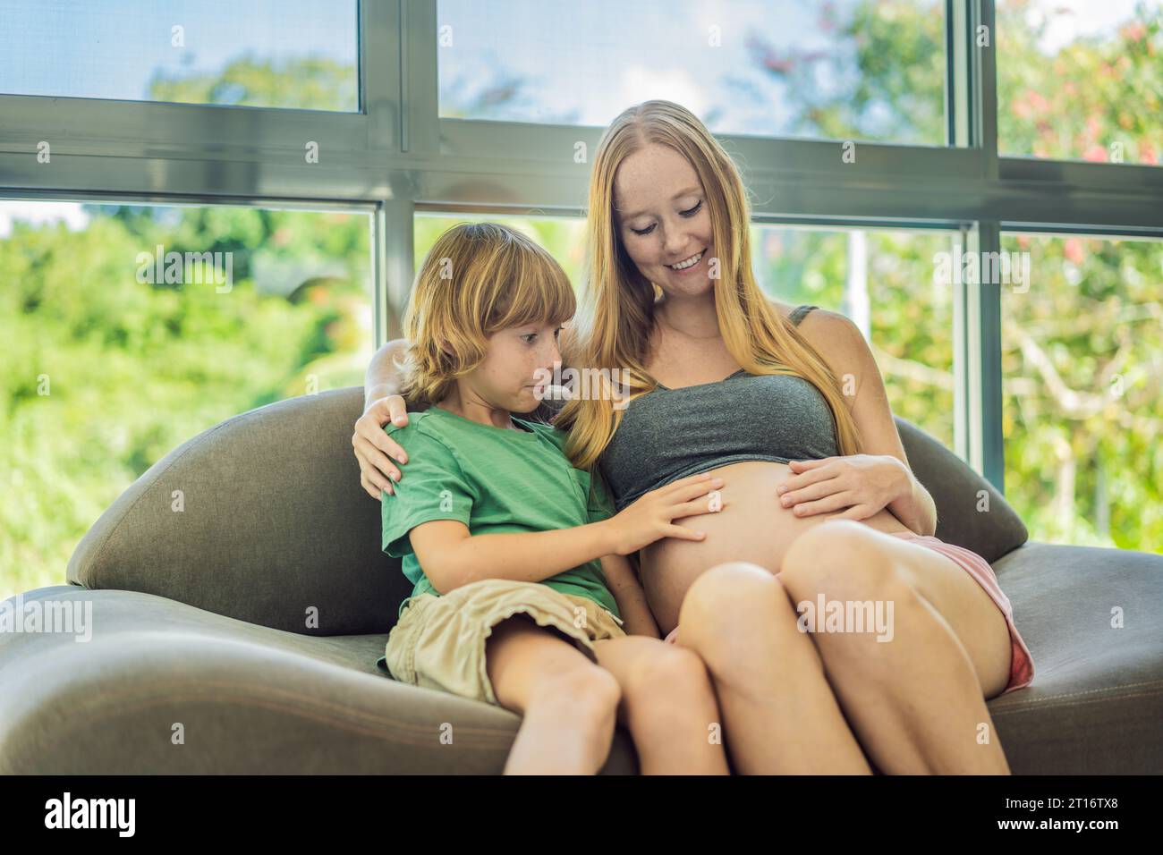 A heartwarming moment pregnant mother and her older son sit on the