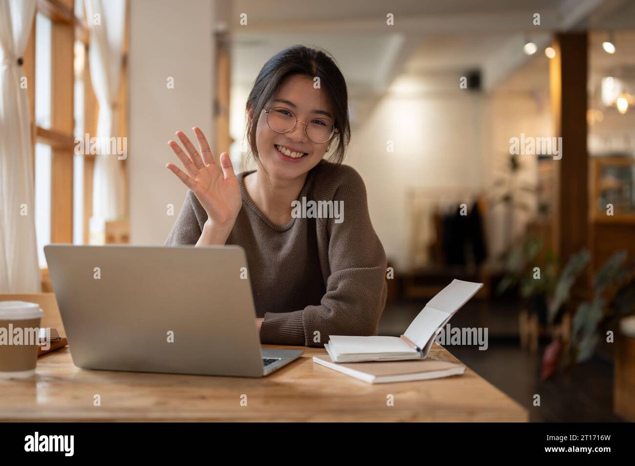 A portrait of a charming and smiling young Asian woman wearing ...