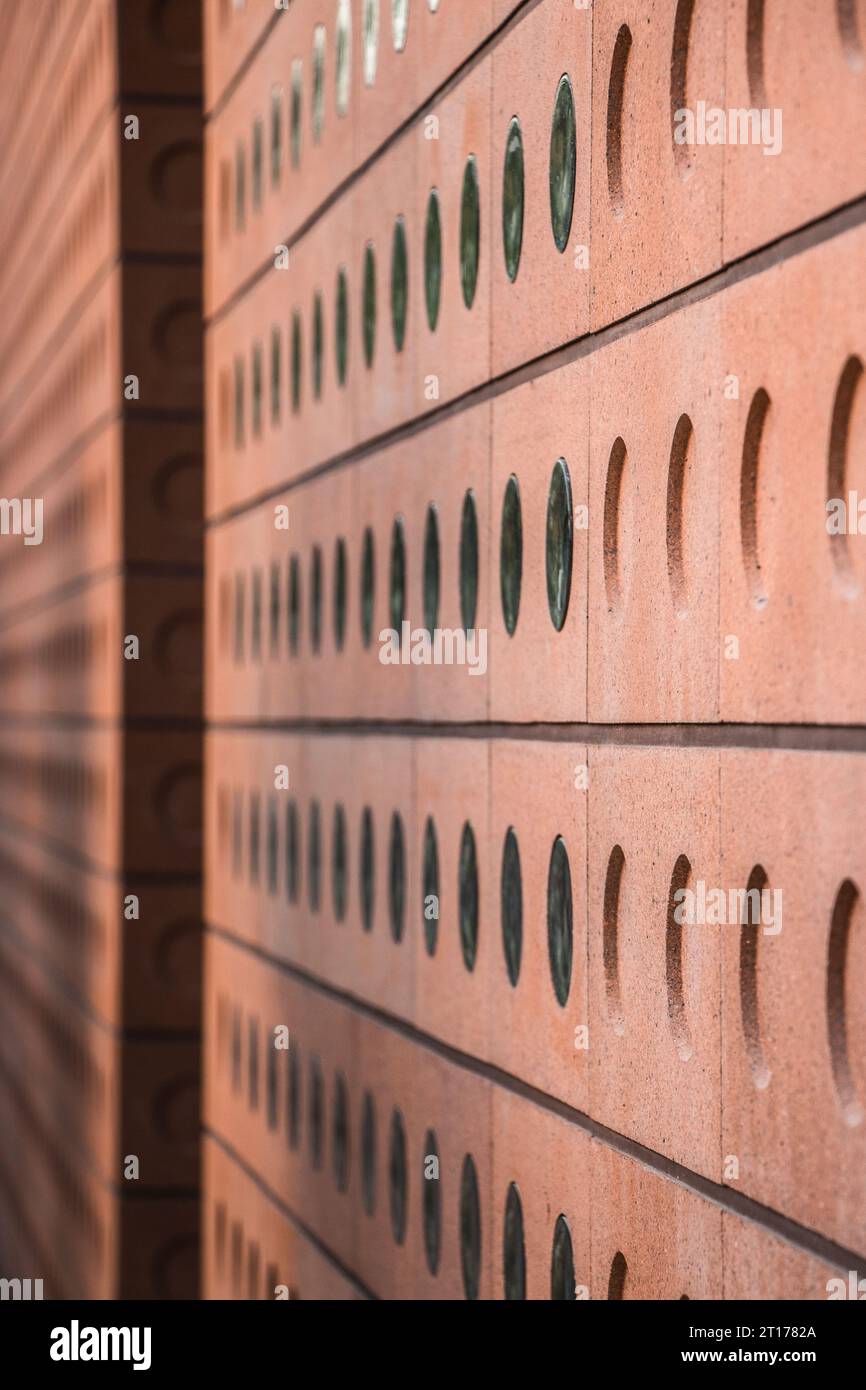 close-up of a modern brick building facade made with patterned perforated orange bricks Stock Photo