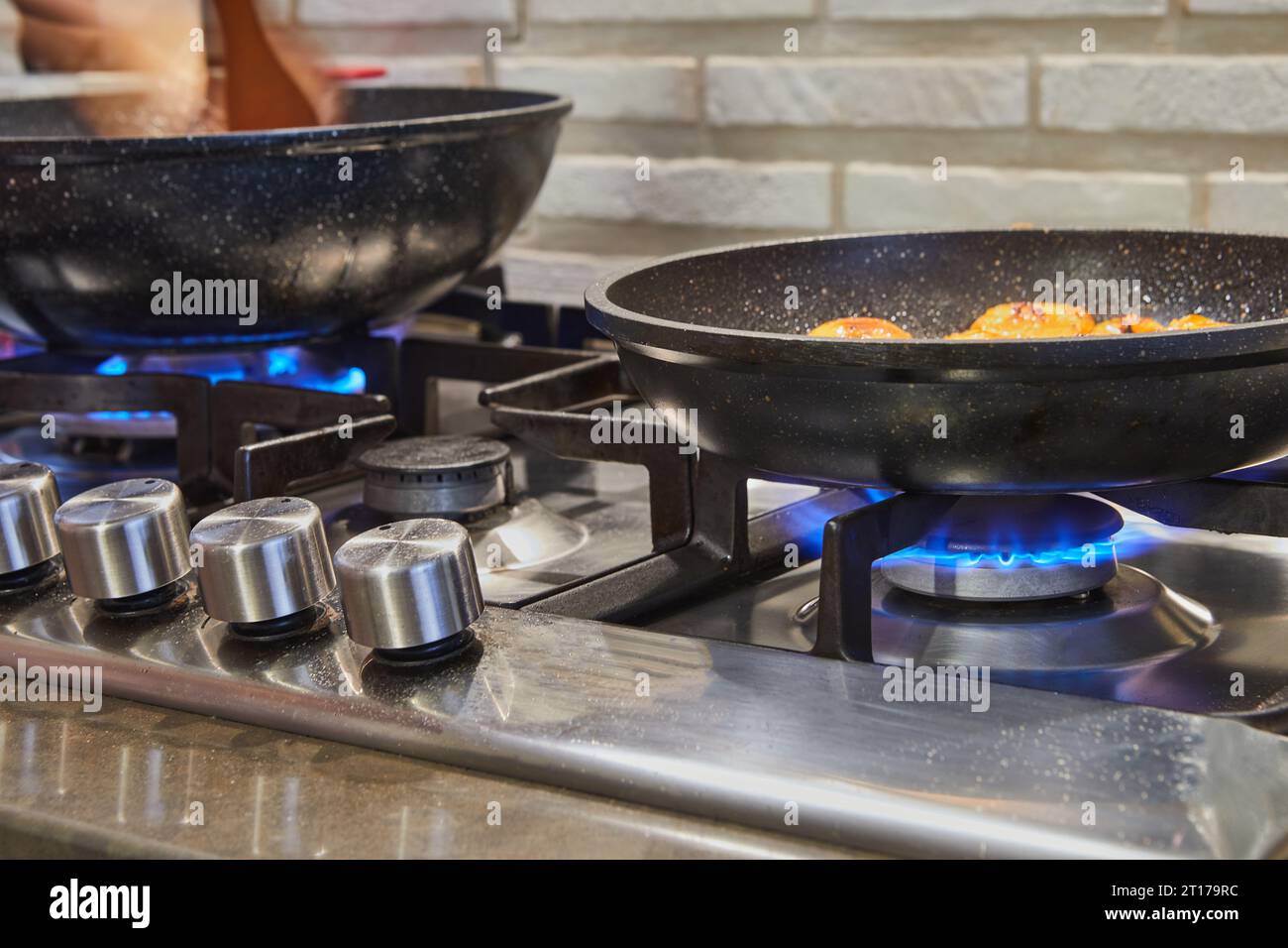 https://c8.alamy.com/comp/2T179RC/frying-pans-on-burner-fire-on-gas-stove-with-dish-being-prepared-2T179RC.jpg