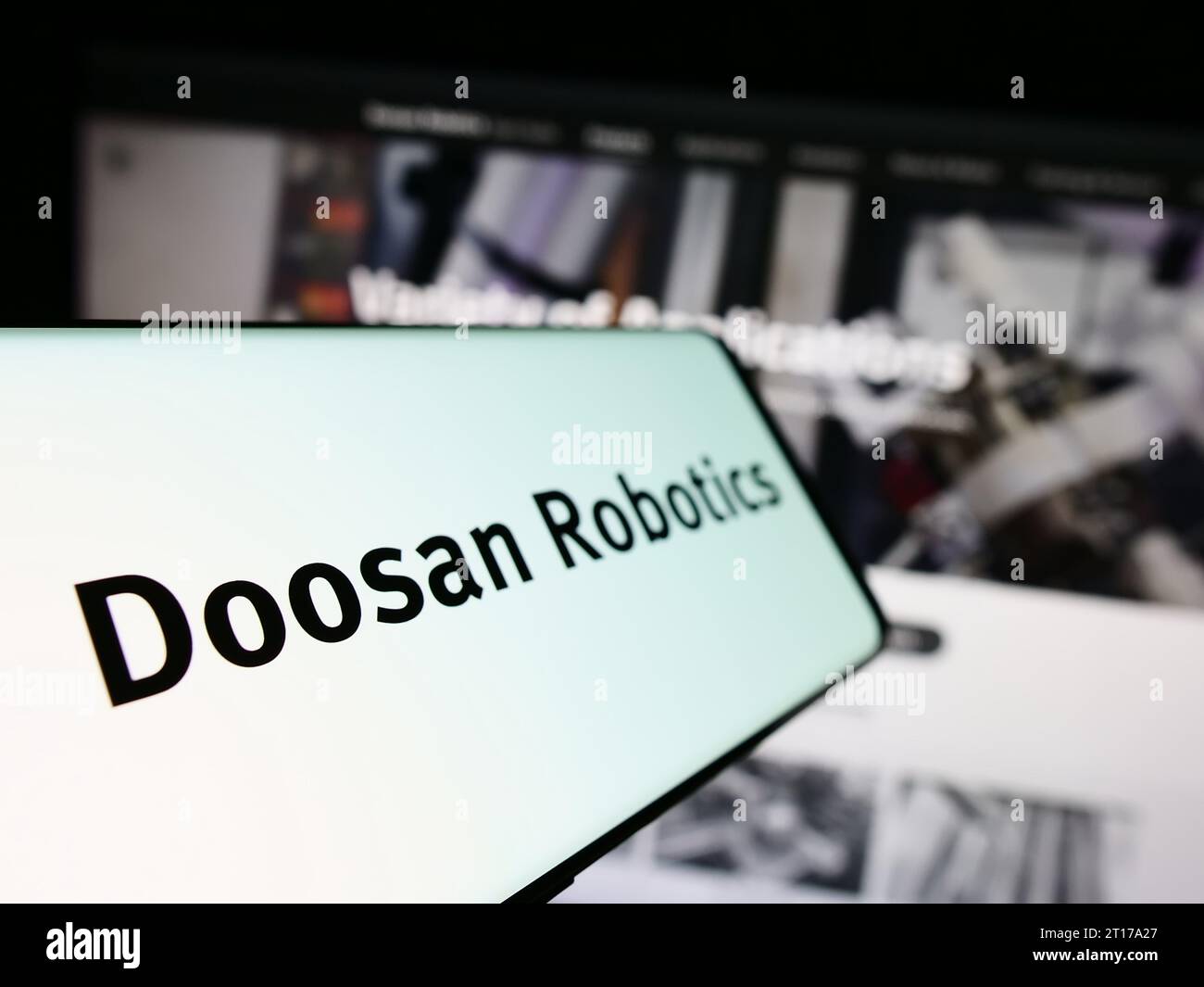 Smartphone with logo of Korean robot company Doosan Robotics Inc. in front of business website. Focus on left of phone display. Stock Photo