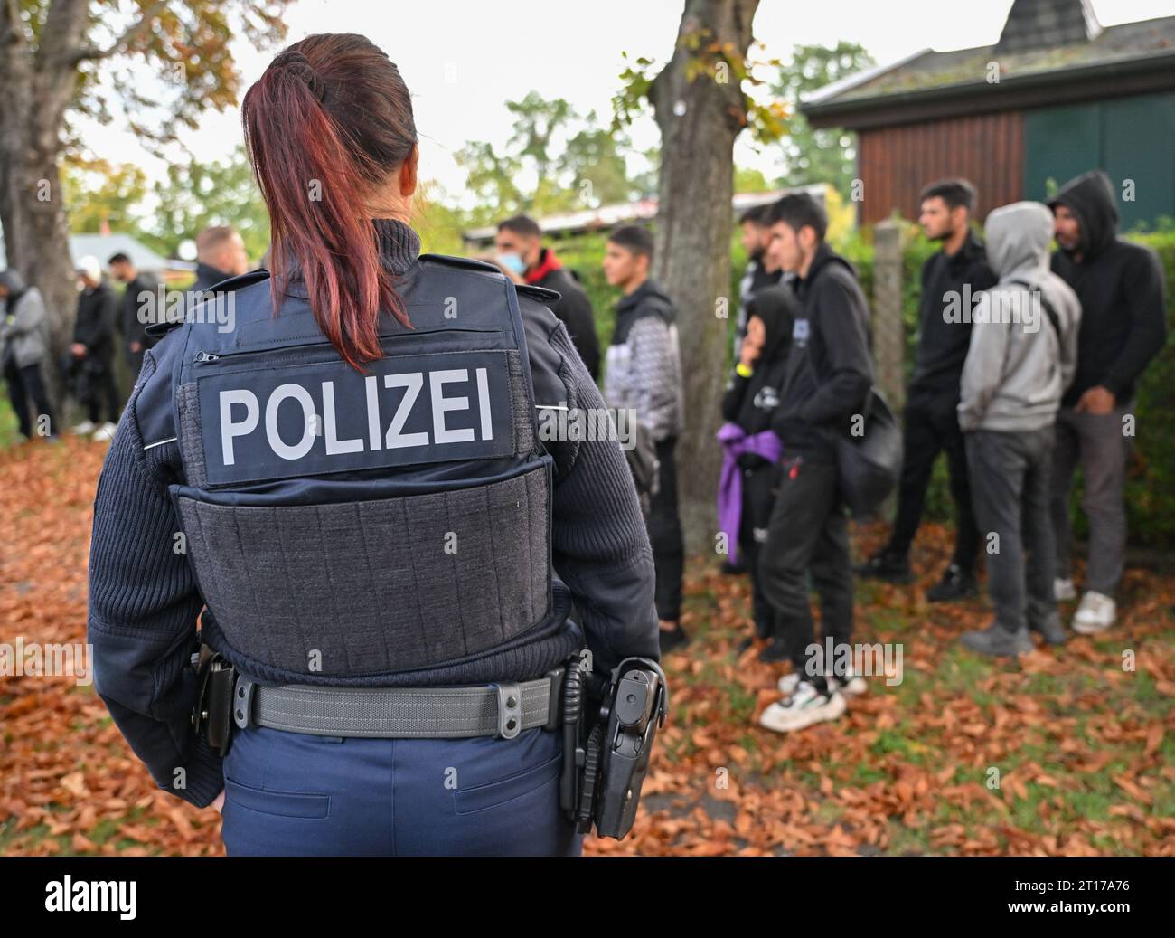 Forst, Germany. 11th Oct, 2023. Illegal migrants are guarded by a female officer of the Federal Police during an apprehension near the German-Polish border in Forst (Lausitz). Credit: Patrick Pleul/dpa/Alamy Live News Stock Photo