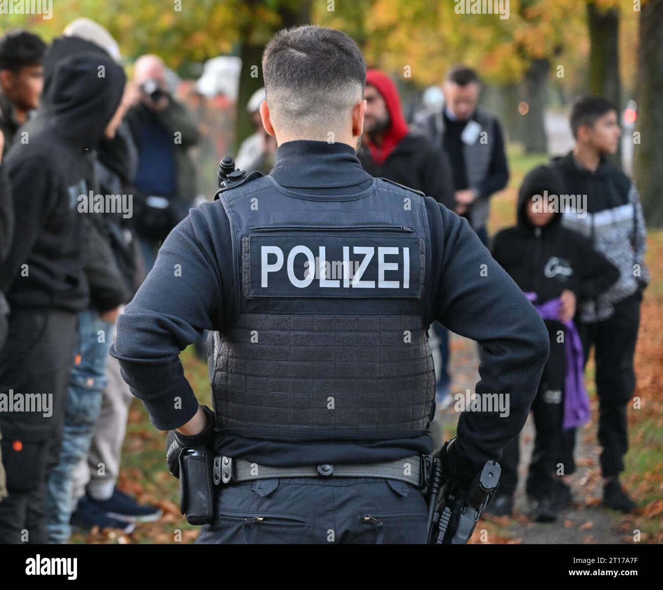 Forst, Germany. 11th Oct, 2023. Illegal migrants are guarded by an officer of the Federal Police near the German-Polish border in Forst (Lausitz). Credit: Patrick Pleul/dpa/Alamy Live News Stock Photo