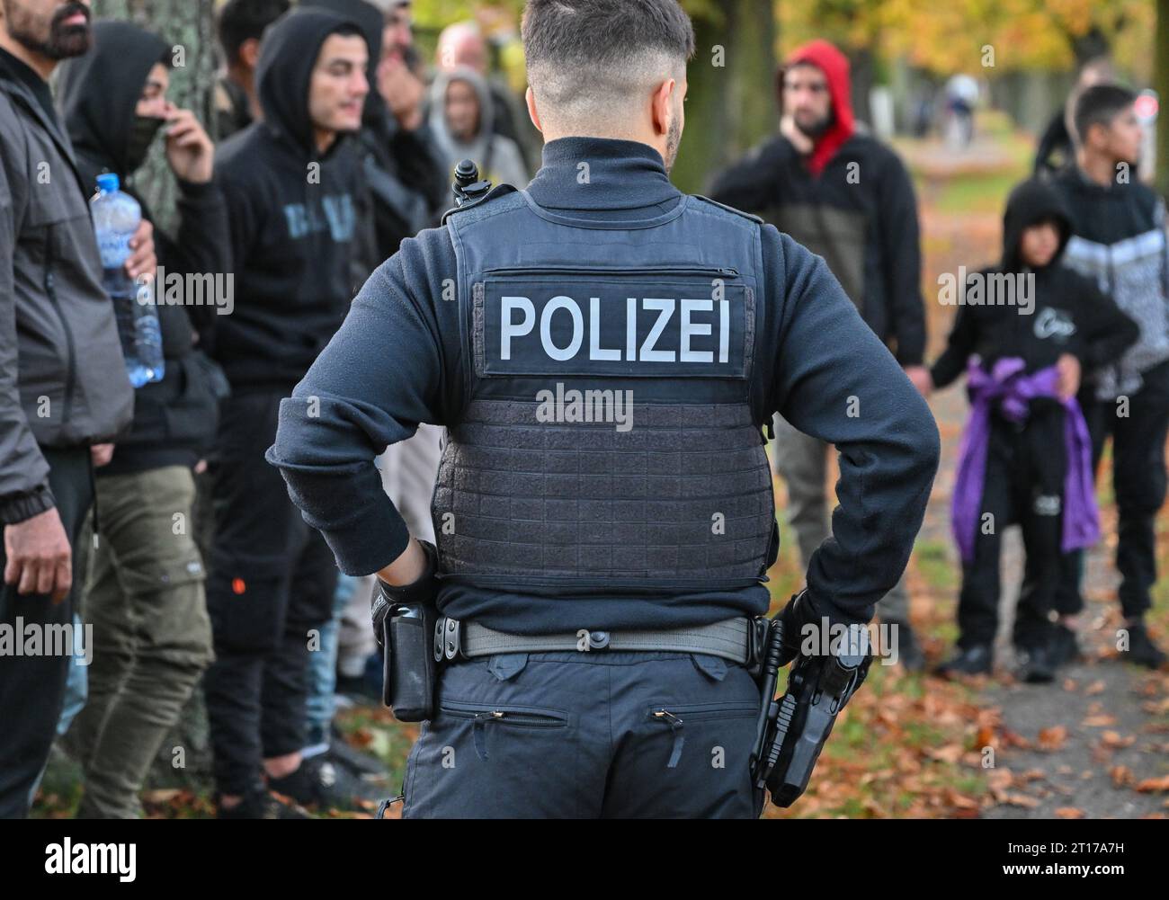 Forst, Germany. 11th Oct, 2023. Illegal migrants are guarded by a federal police officer near the German-Polish border in Forst (Lausitz). (to dpa 'Endstation Forst: Wie Schleuser Migranten nach Deutschland bringen') Credit: Patrick Pleul/dpa/Alamy Live News Stock Photo