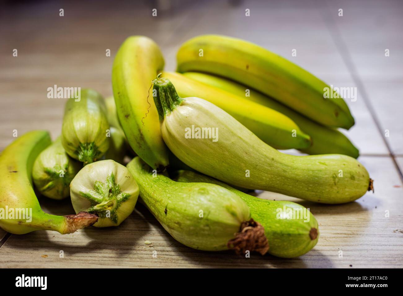 green bananas lie next to green zucchini Stock Photo Alamy