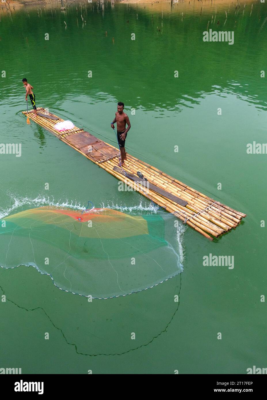 Indigenous men catching fish using net Stock Photo Alamy
