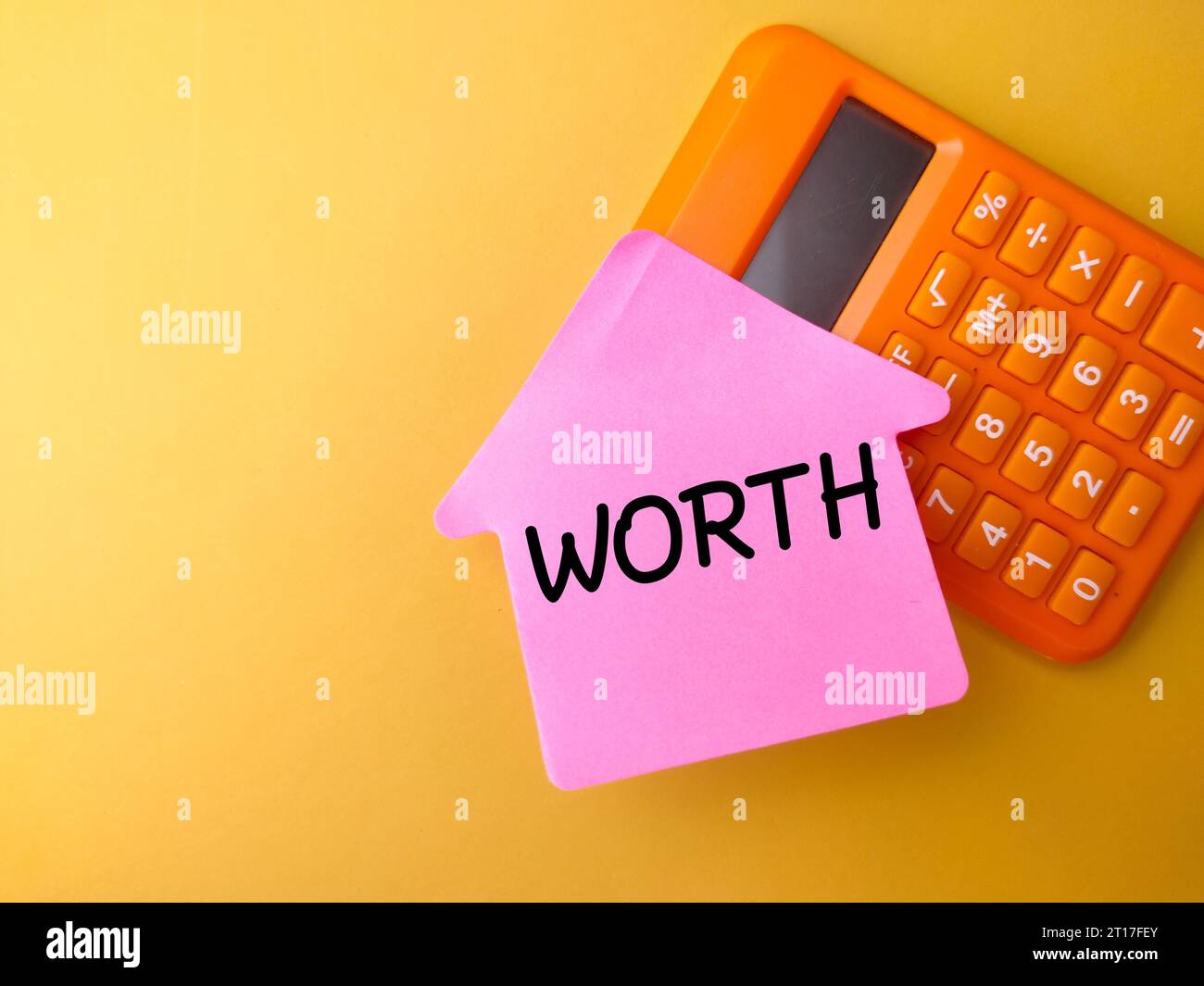 Business concept. Calculator and sticky note with the word WORTH Stock ...