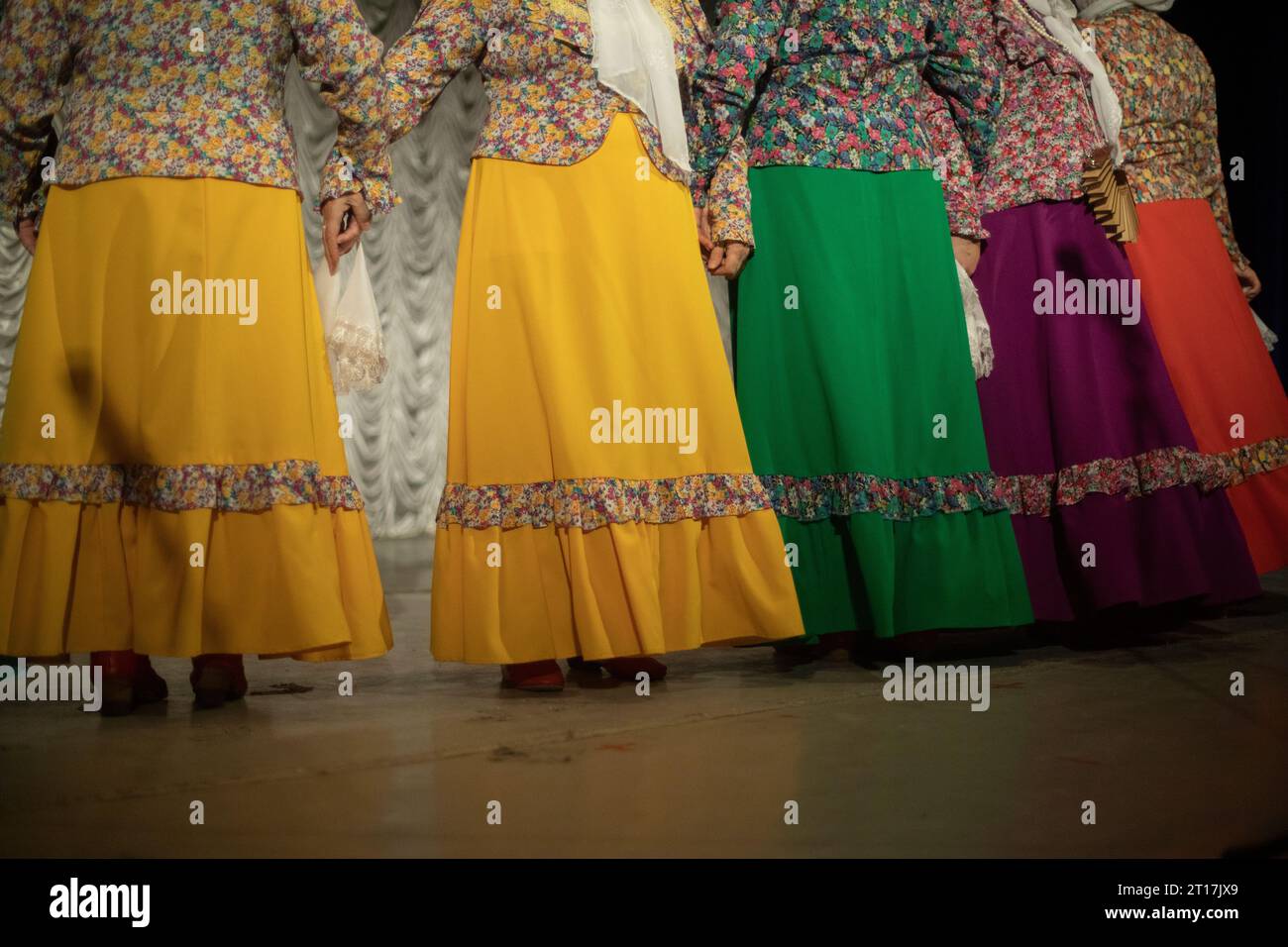 Folk costumes. Women perform on stage. Folklore ensemble. Beautiful