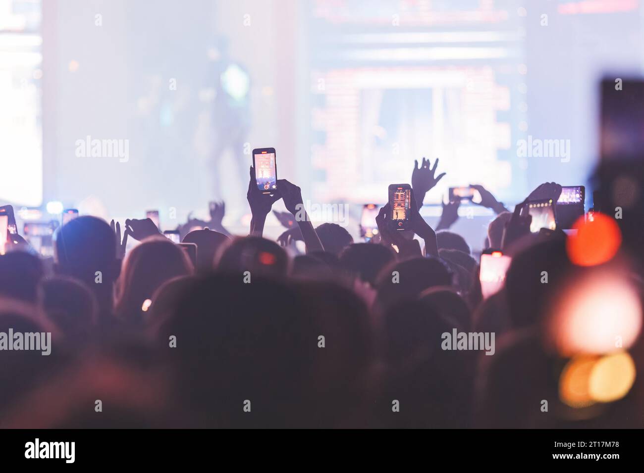 People taking pictures and recording at the big concert. Closeup shot