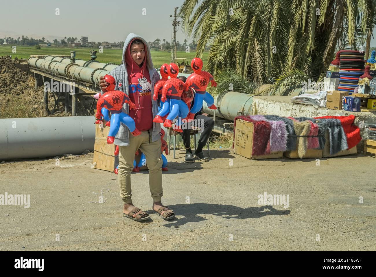 Straßenszene, Kinderarbeit, junger Mann verkauft Spiderman Figuren, Strasse 75 zwischen Luxor und Qina, Ägypten Stock Photo