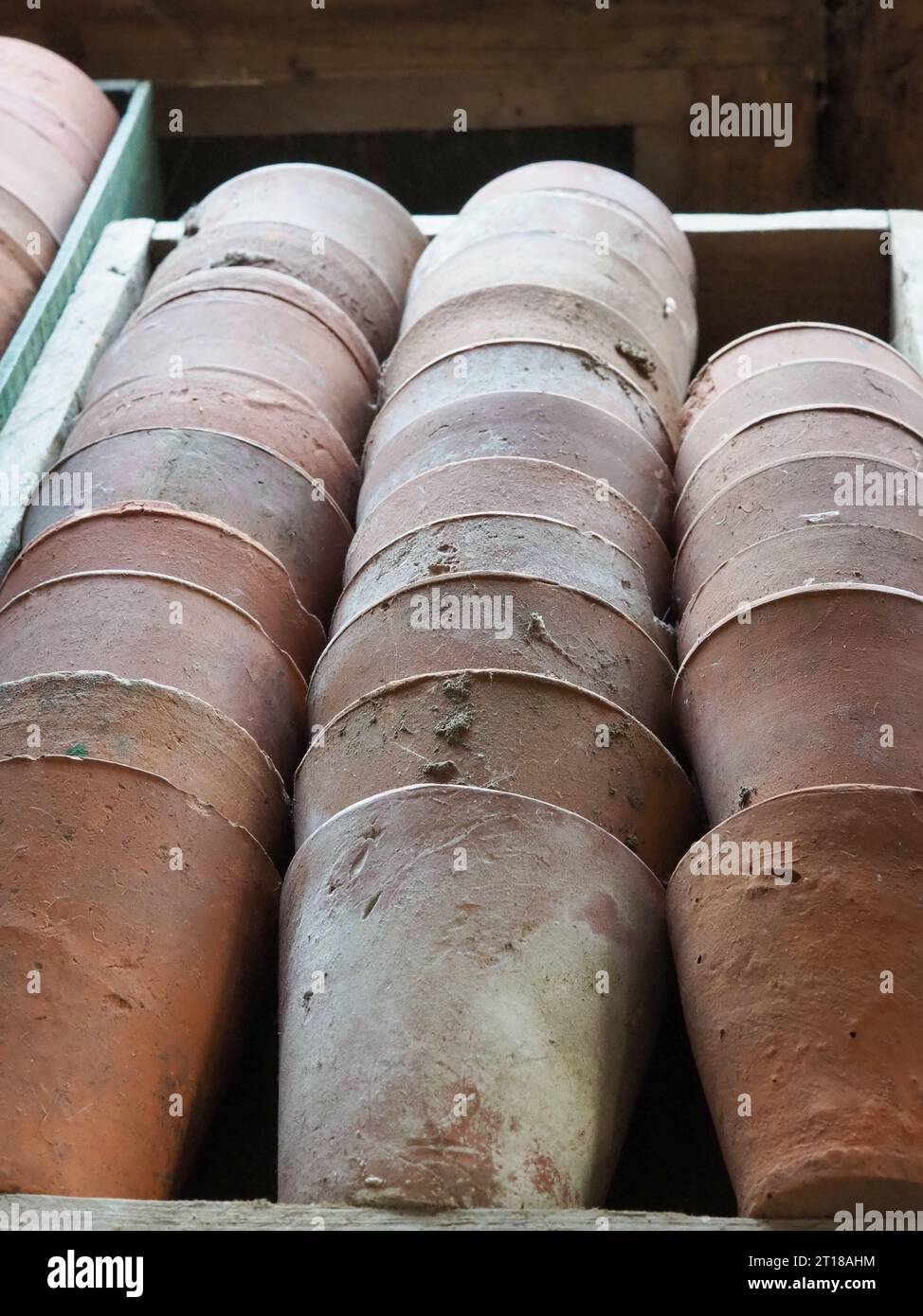 Close up of vintage rustic terracotta garden pots stacked in a wooden