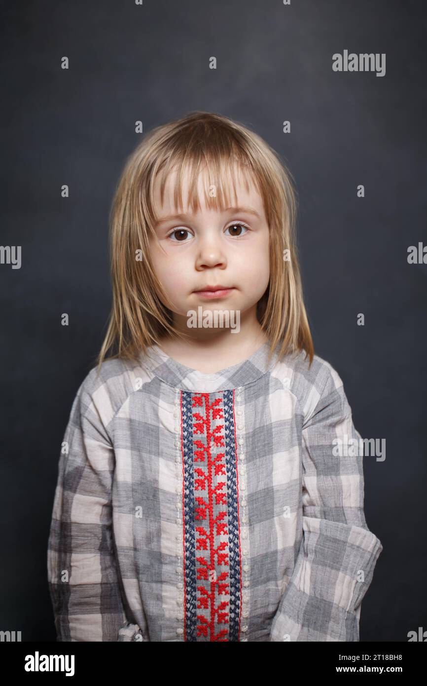 Cute little baby girl on blackboard background, kid 3 years old Stock Photo