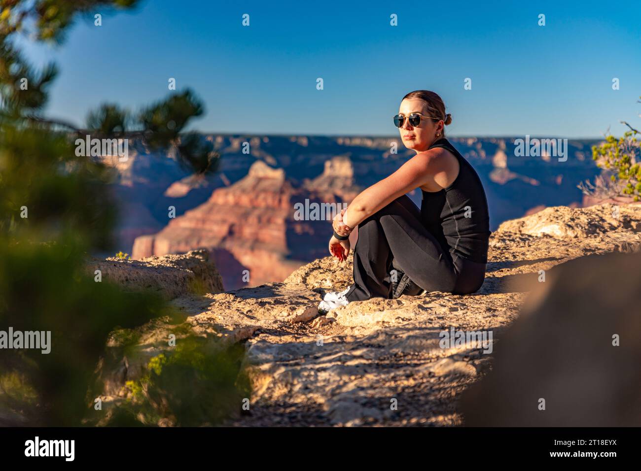 The girl relaxes at sunset over the Grand Canyon in the USA Stock Photo