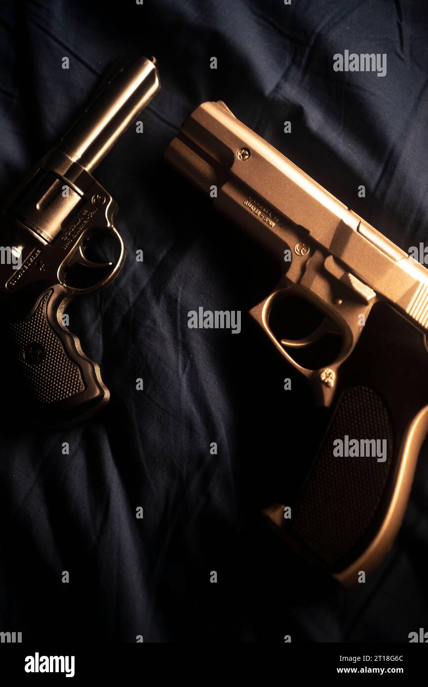 Pistol gun on bed sheet still life crime thriller book cover design. Stock Photo