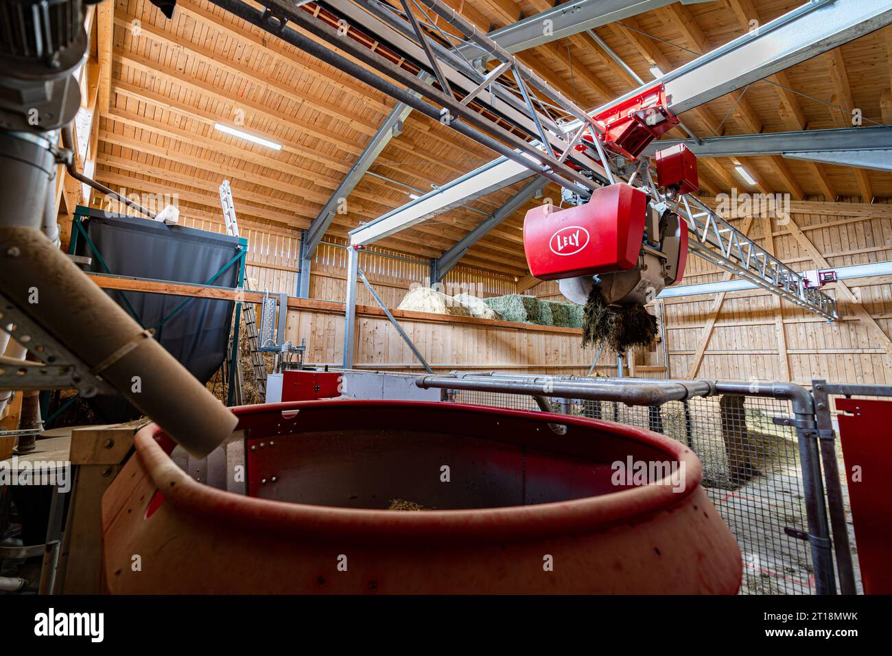 Moderner Fütterungsroboter von Lely bei der Zusammenstellung der Futterration im Futterraum. Moderner Fütterungsroboter sucht sich die Futterkomponenten in einem eigens dafür vorgesehenen Futterlager selbtsständig zusammen. Über Laserabtastung kann ein separater Greifarm die Position z.B. von vorher dort bereitgestellten Silageblöcken erkennen und den mobilen Futterroboter befüllen. Die Komponenten werden im Voratsbehälter des Roboters gemischt und entlang einer Bahn im Kuhstall den Kühen vorgegeben. Süddeutschland Bayern Deutschland *** Modern feeding robot from Lely composing the feed ration Stock Photo