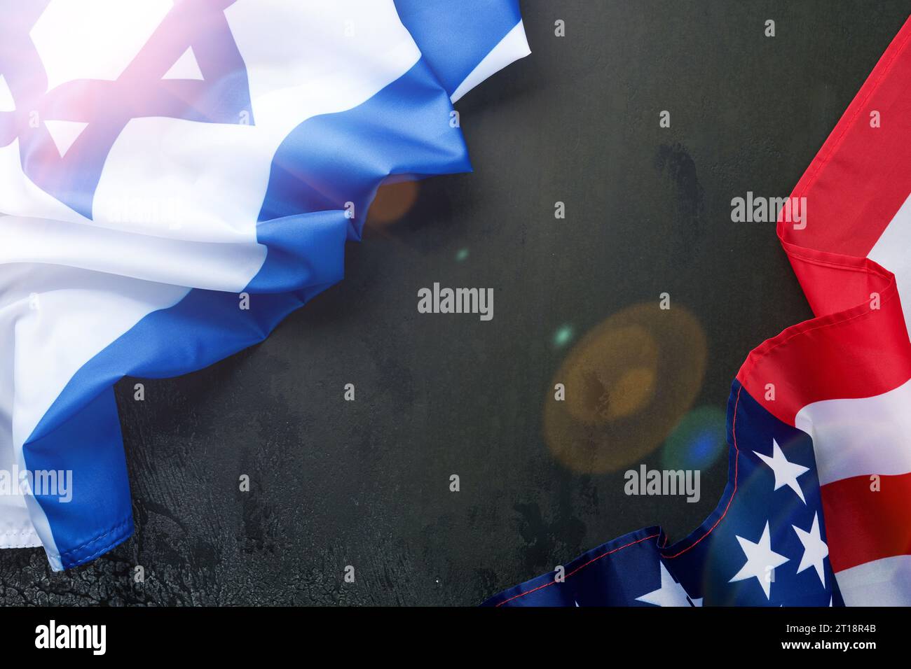 USA Israel flags. Two American and Israeli flags lie on black old concrete texture background opposite each other conveys partnership between two stat Stock Photo