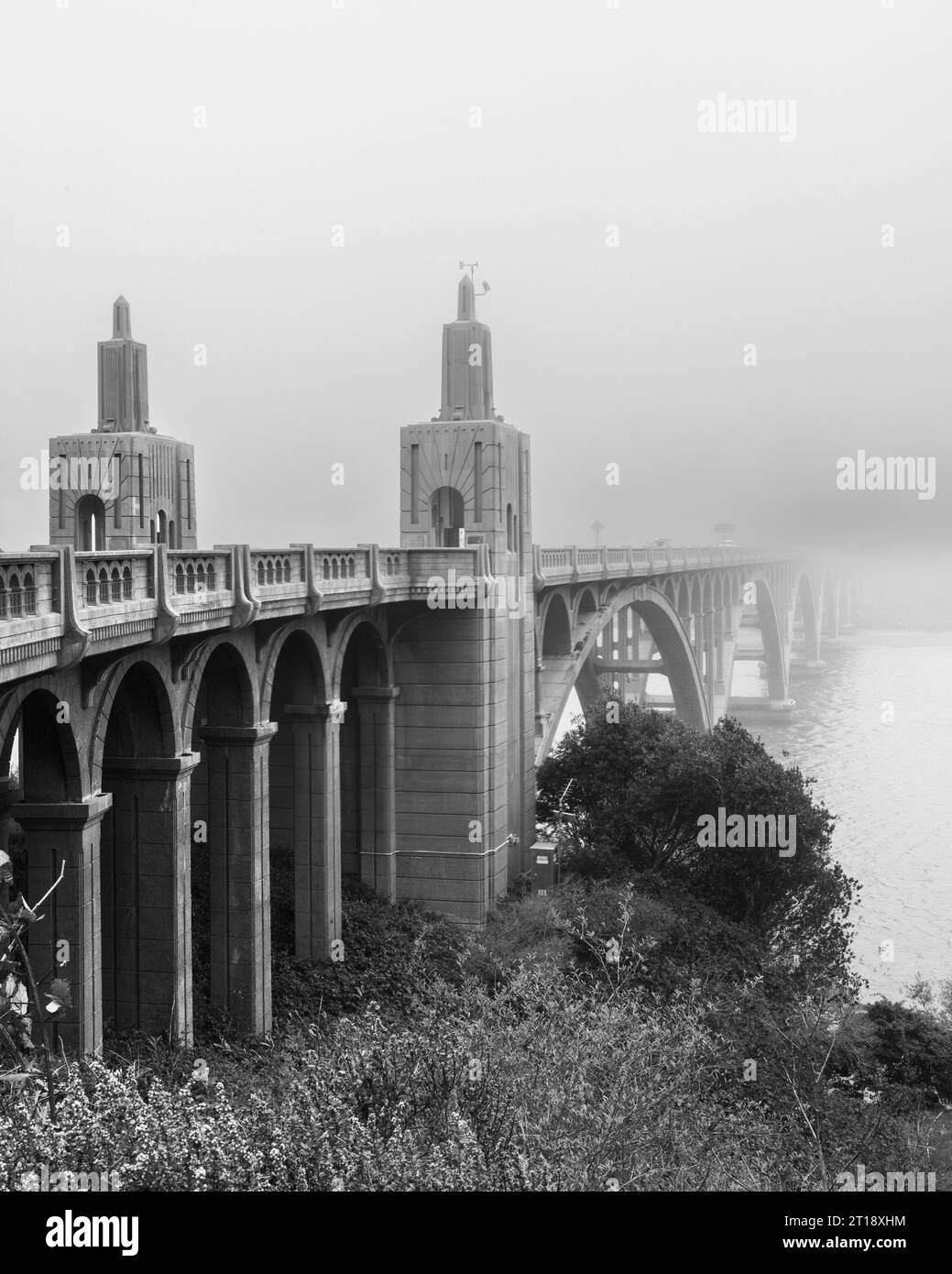 The Isaac Lee Patterson Bridge on US 101 over the mouth of the Rogue River in Gold Beach Oregon on a foggy day in black and white. Stock Photo