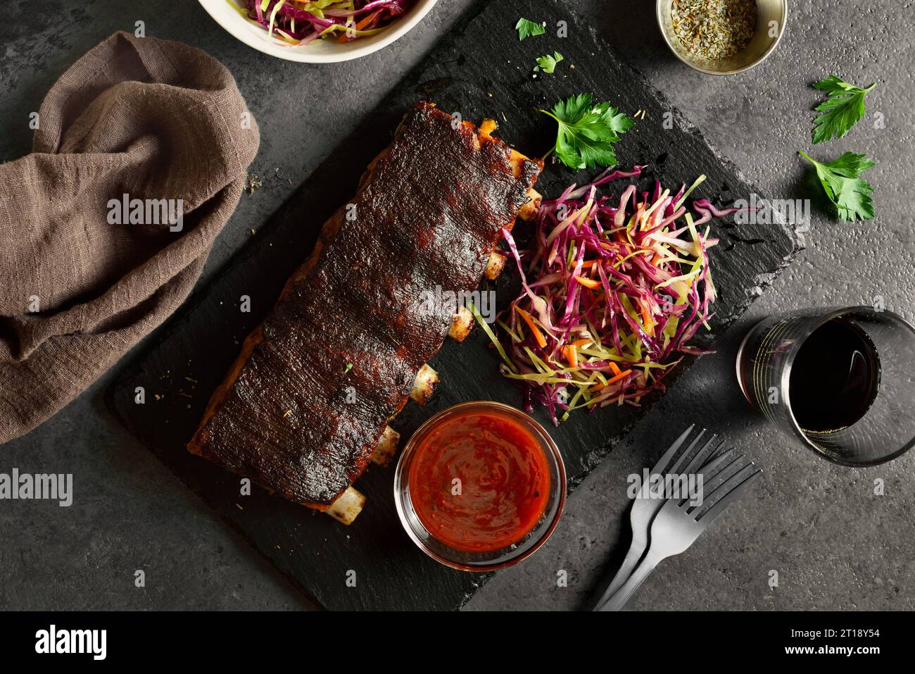 Grilled spare ribs on board over dark stone background. Top view, flat lay Stock Photo