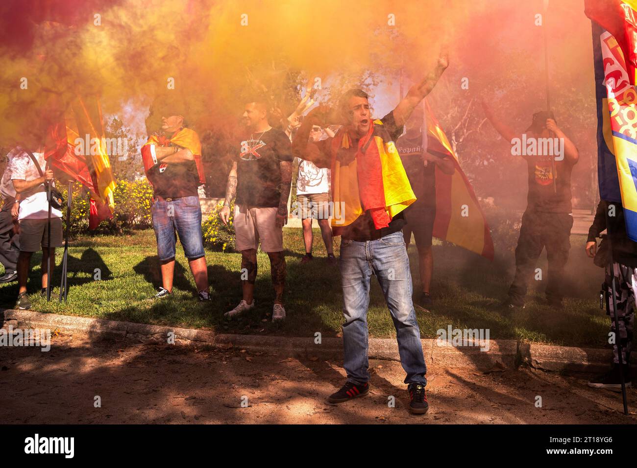 Barcelona, Spain. 12th Oct, 2023. A protester raises his hand in the Nazi salute surrounded by red and yellow smoke representing the Spanish colours during the ultra-right demonstration on 12 October in Montjuic, Barcelona. Demonstration on 12 October, Columbus Day. Credit: SOPA Images Limited/Alamy Live News Stock Photo
