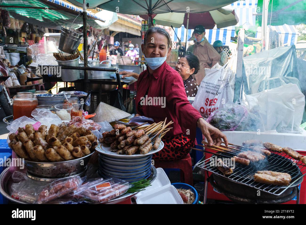 Binh Tay Market Scene, Vendor Roasting Meat over Charcoal, Ho Chi Minh City, Vietnam. Stock Photo