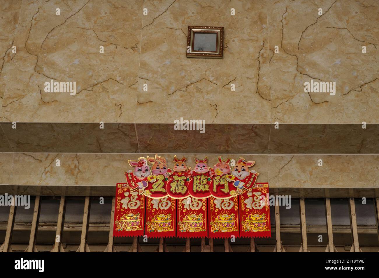 Small Mirror above the Door Scares Demons away from the House. Ho Chi Minh, Vietnam. Red-gold banner proclaims happiness and good fortune. Stock Photo