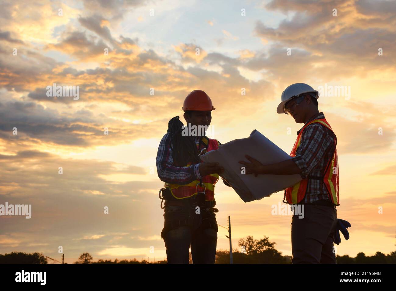 Two construction workers looking at plans on a construction site, Thailand Stock Photo