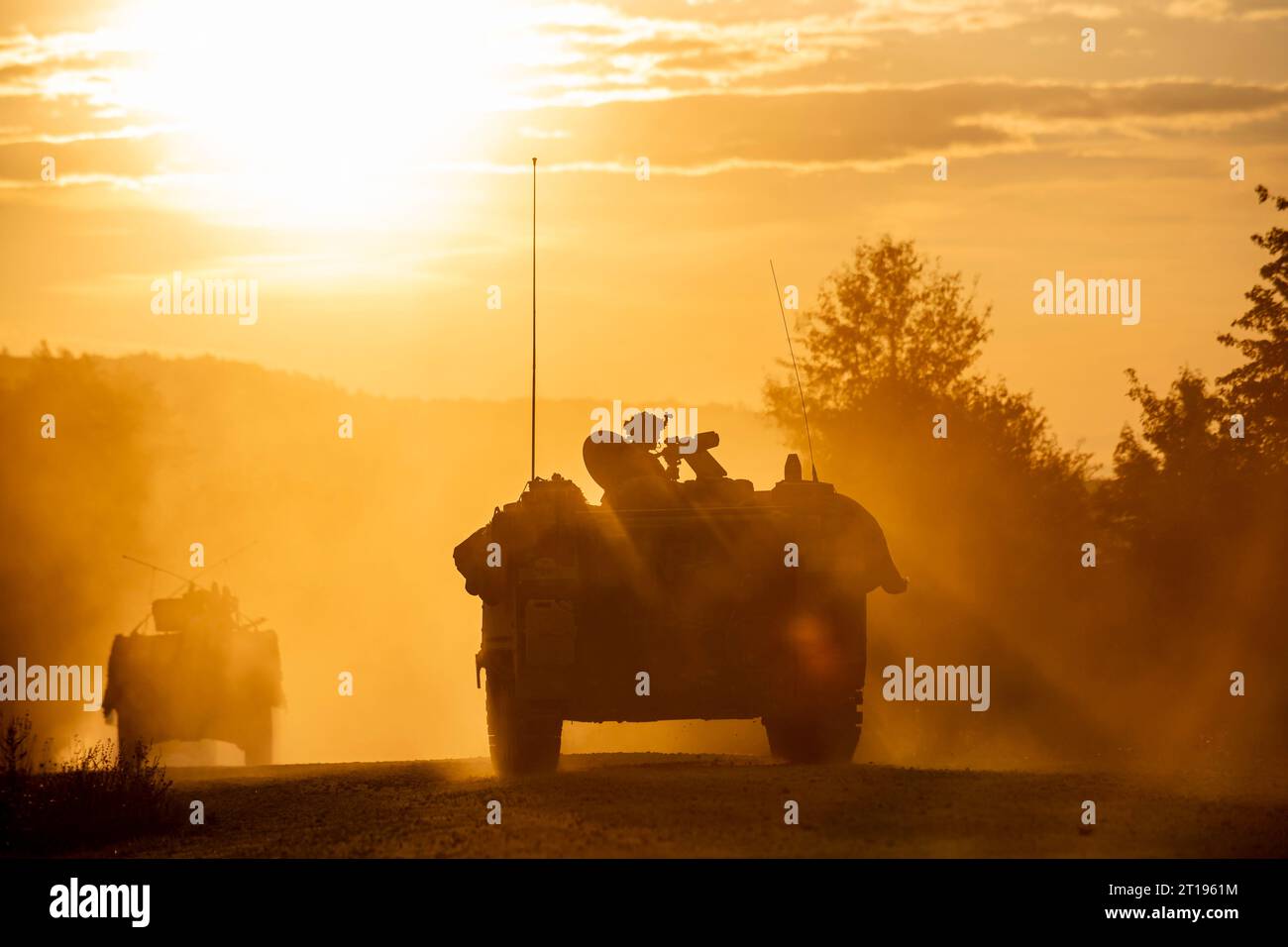 Hohenfels, Germany . 13 September, 2023. A convoy of U.S. Army soldiers with the1st Battalion of the 4th Infantry Regiment roll through a training village with armored vehicles at sunset during Saber Junction 23 at the Joint Multinational Readiness Center, September 13, 2023 near Hohenfels, Germany.  Credit: SFC Michel Sauret/U.S Army/Alamy Live News Stock Photo