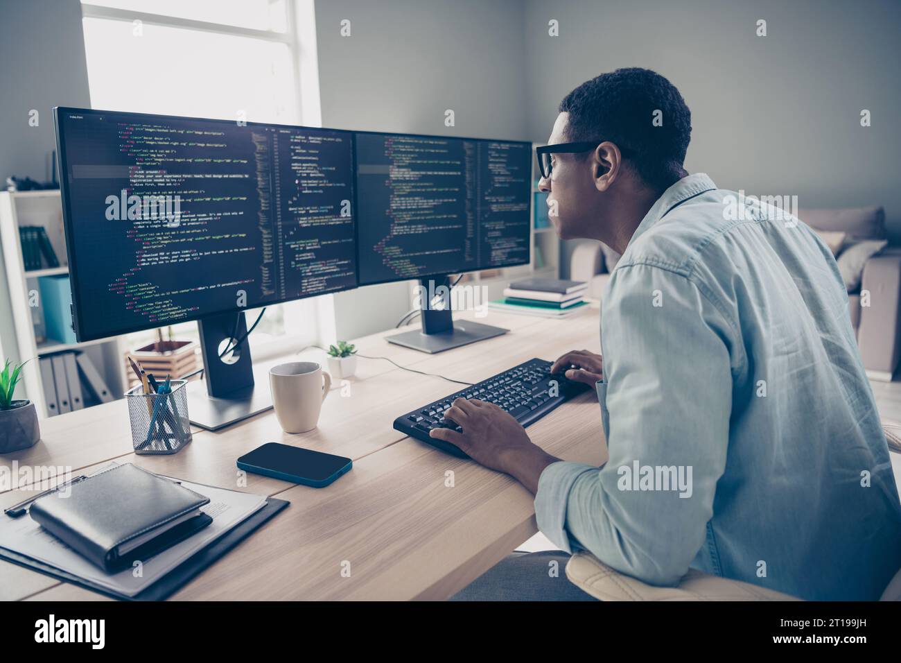Side photo of focused concentrated serious programmer guy researching code mistakes errors debug fixing looking for solution in office Stock Photo