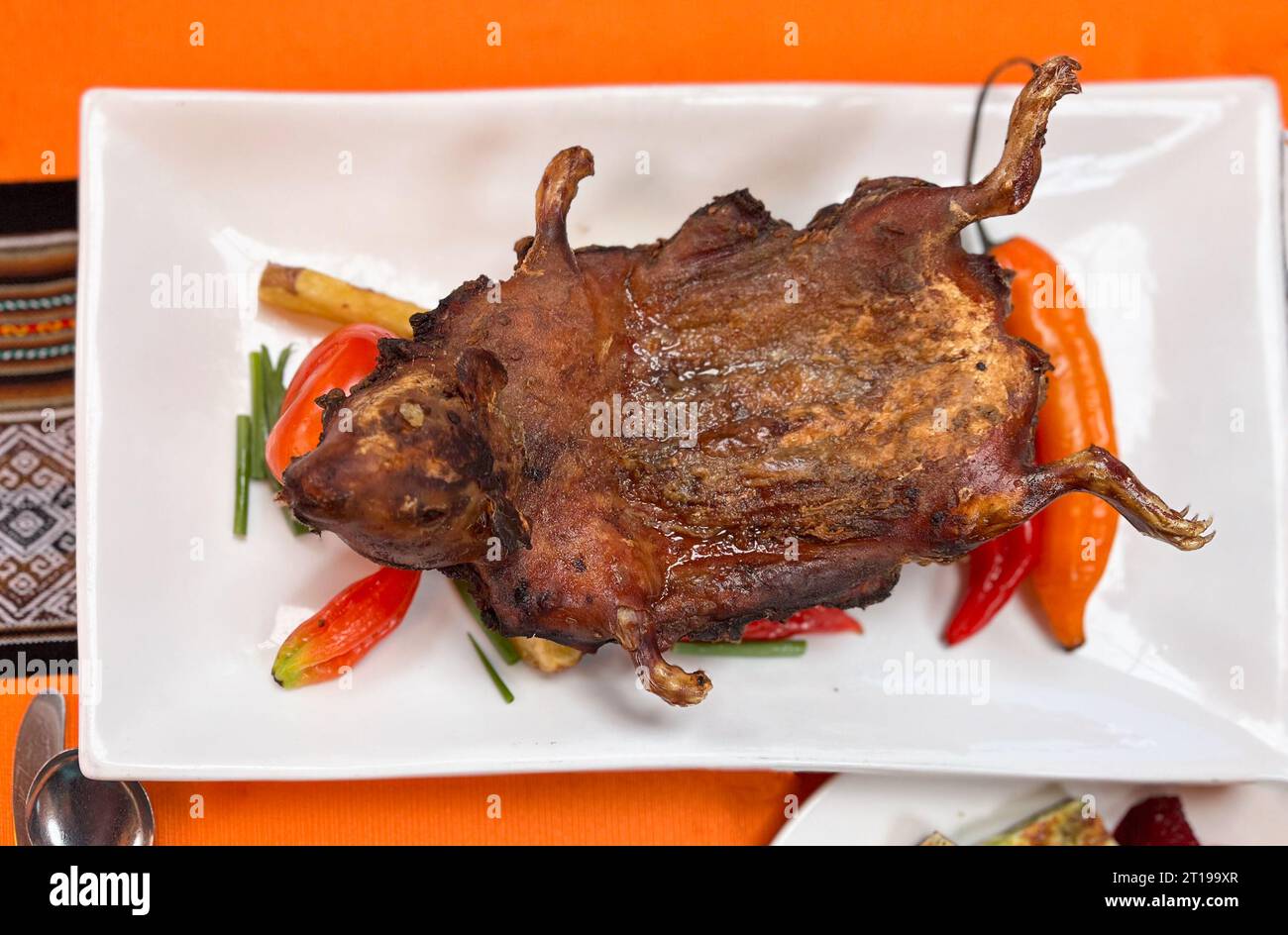 Traditional Peruvian roasted cuy (guinea pig) with vegetables Stock Photo