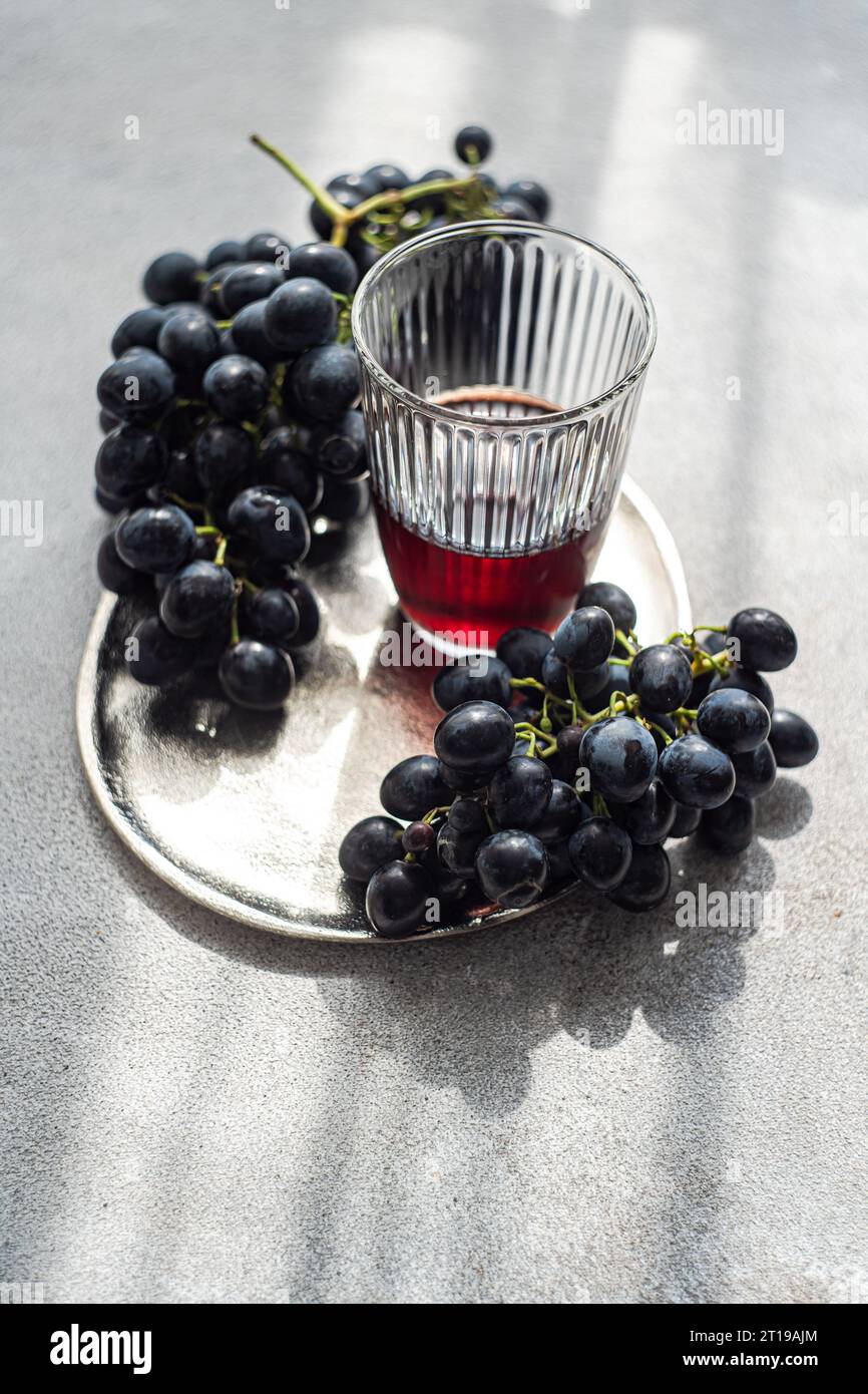 Overhead view of a glass of red wine with bunches of saperavi black grapes Stock Photo