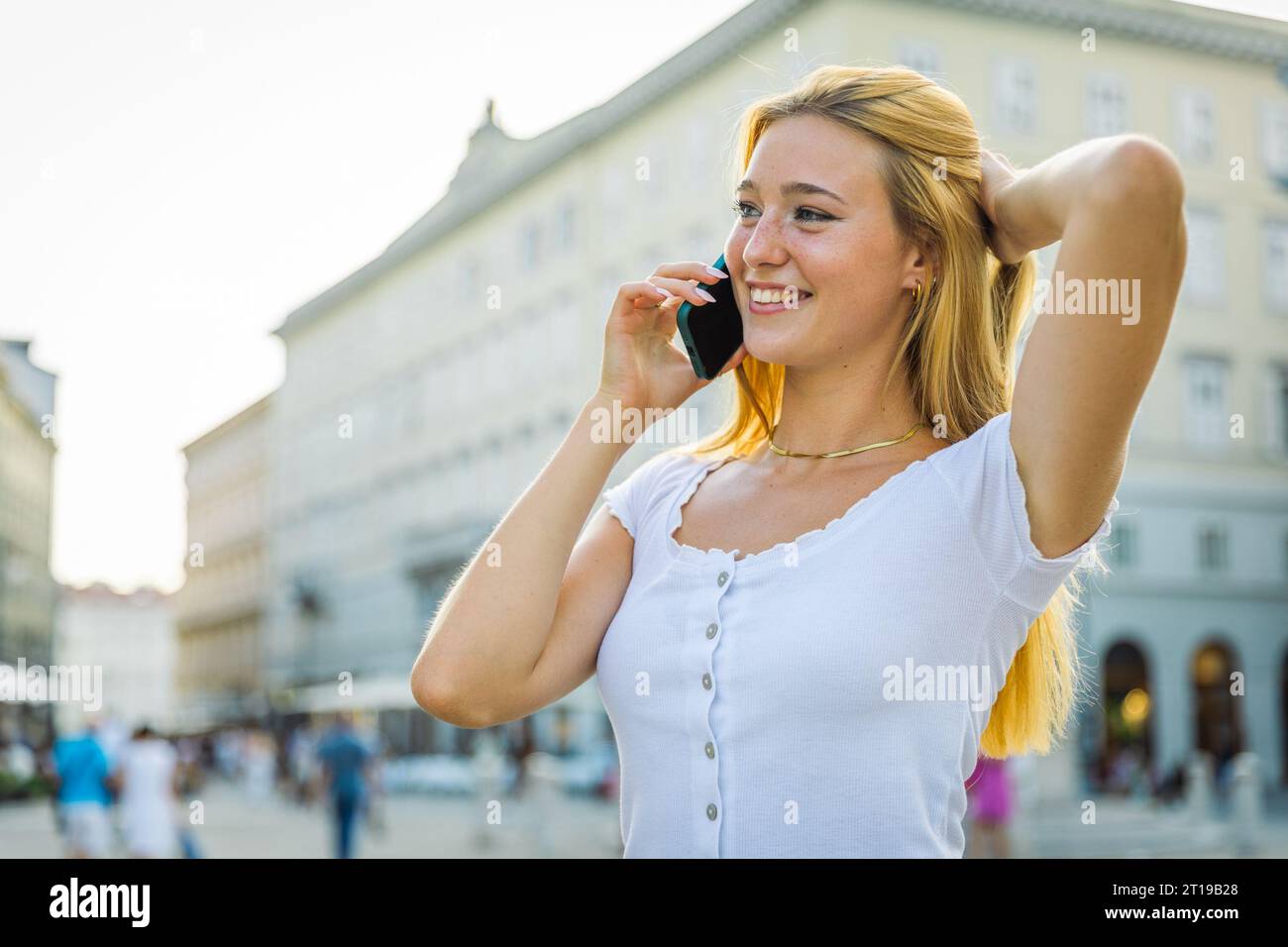 A woman makes a phone call and is happy during the conversation Stock Photo