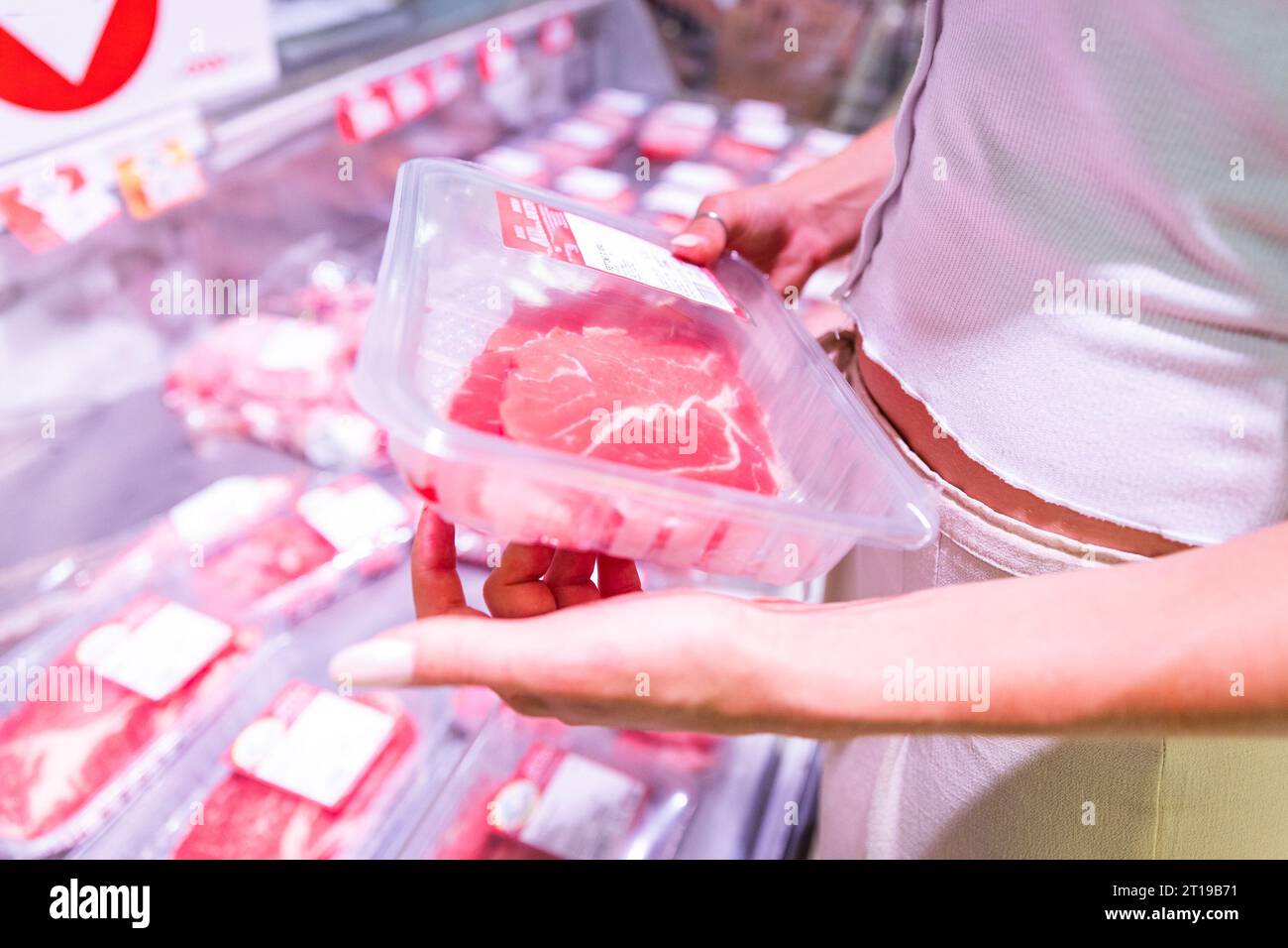 Close-up of the hands of a woman who is choosing the meat to buy at the supermarket Stock Photo