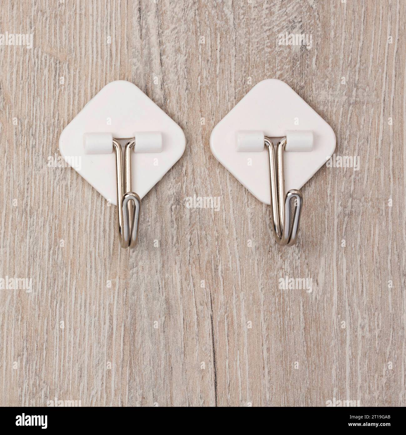 Two plastic adhesive utility wall fixed hooks with metal hooks for hanging clothes Stock Photo