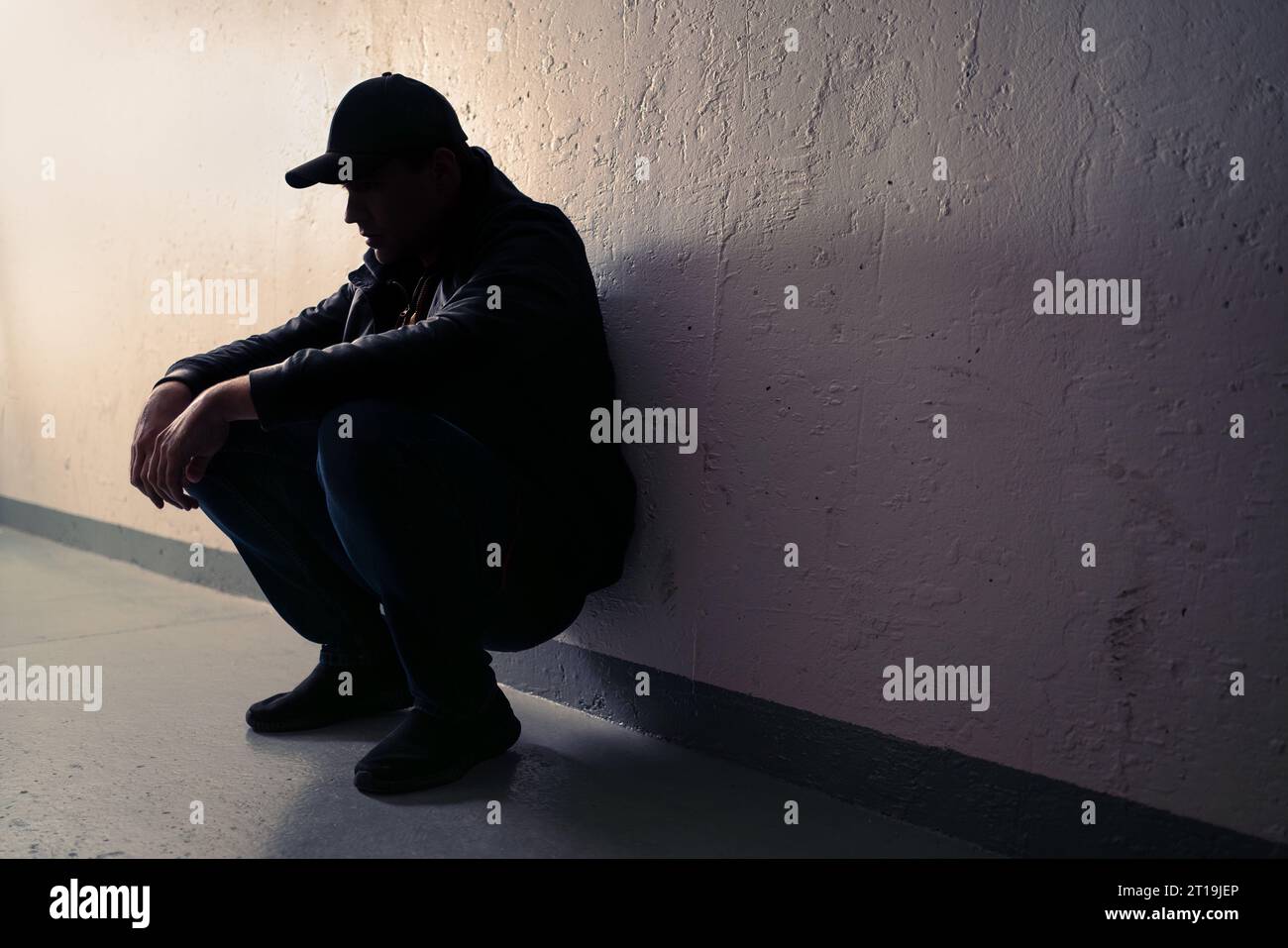 Man with trauma, shame or anxiety. Sad desperate young guy or teenage boy. Drug addiction or despair. Criminal outcast or homeless person with stress. Stock Photo