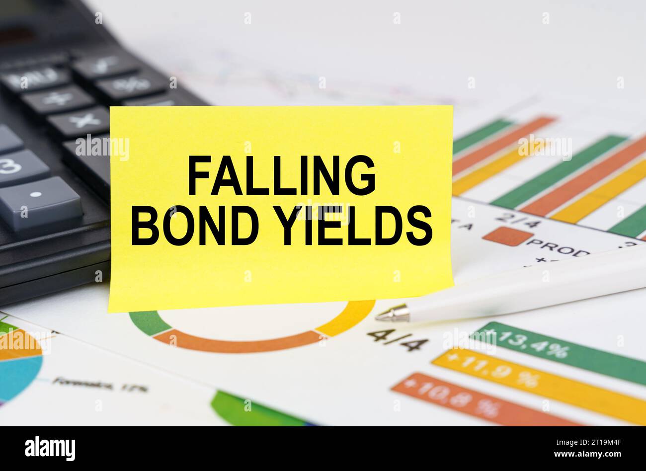 Business concept. On business reports there is a calculator and a sign with the inscription - falling bond yields Stock Photo