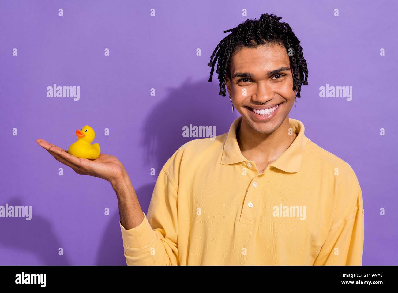 Photo of cheerful youngster guy wear yellow stylish shirt holding hand ...