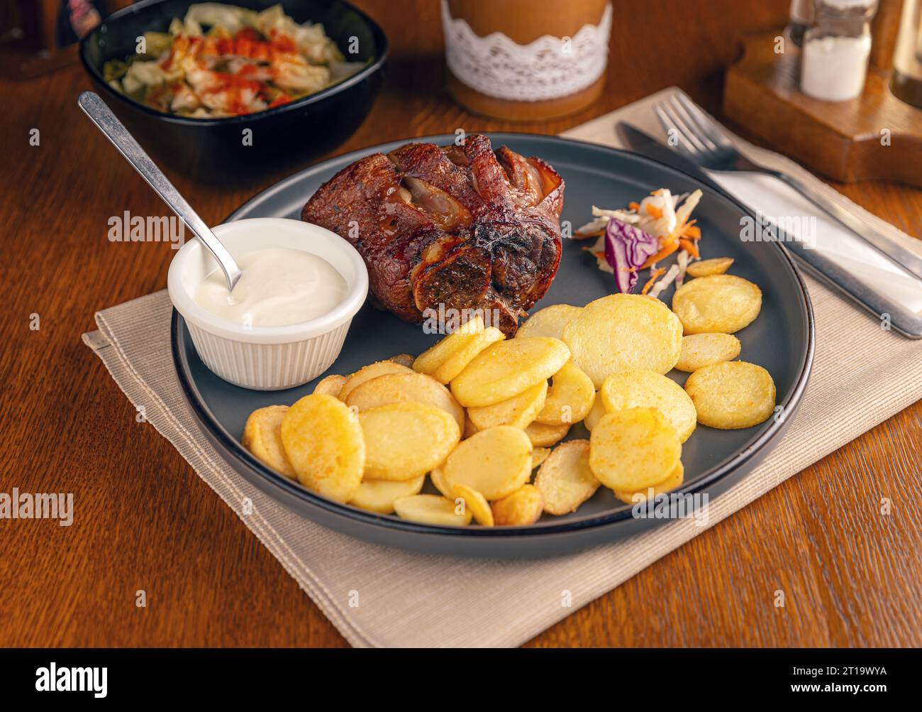 Crispy grilled ham hock served with fries and sauce. Roasted pork knuckle with potatoes Stock Photo