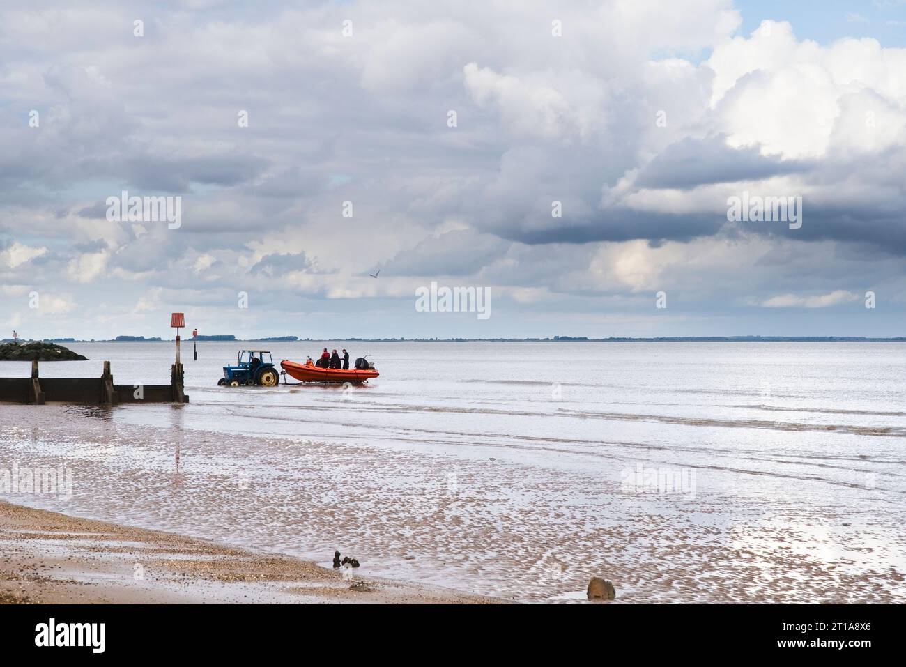 A tractor towing a rib boat out of the water at Cleethorpes beach Stock Photo