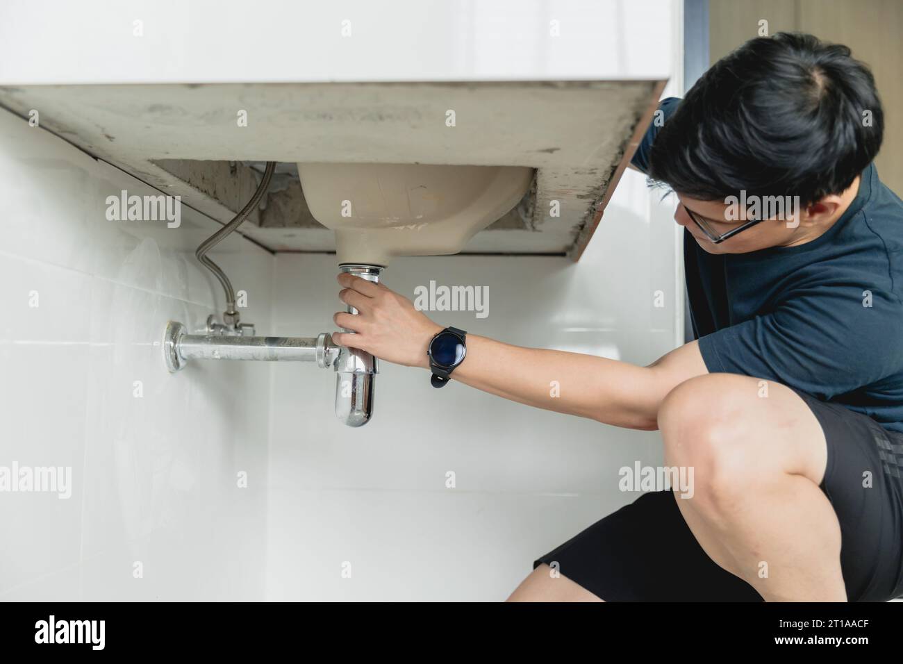 man diy repair sink faucet pipe leak husband working as handyman at home. Stock Photo