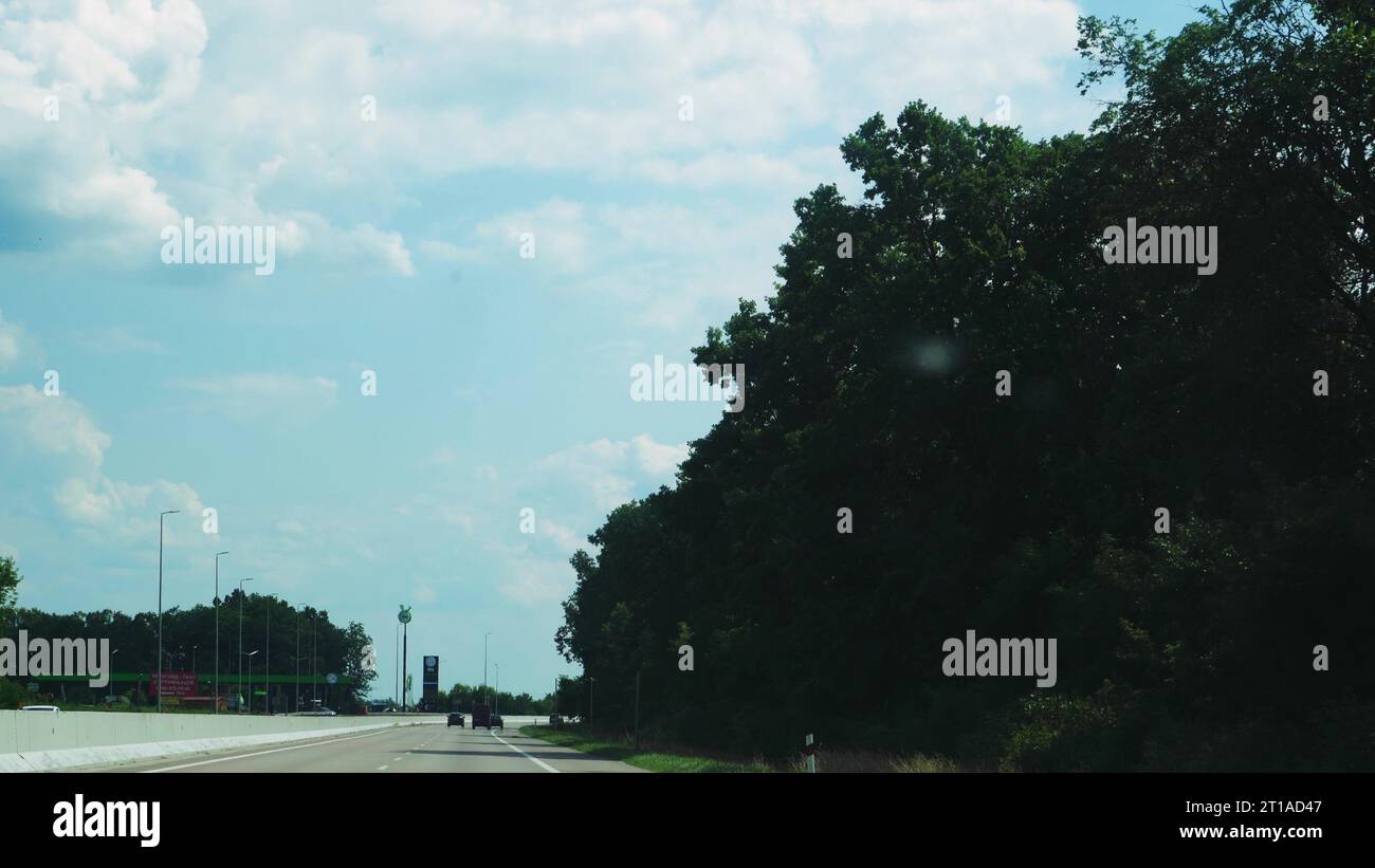 View through the side window of a car in motion along the road along ...